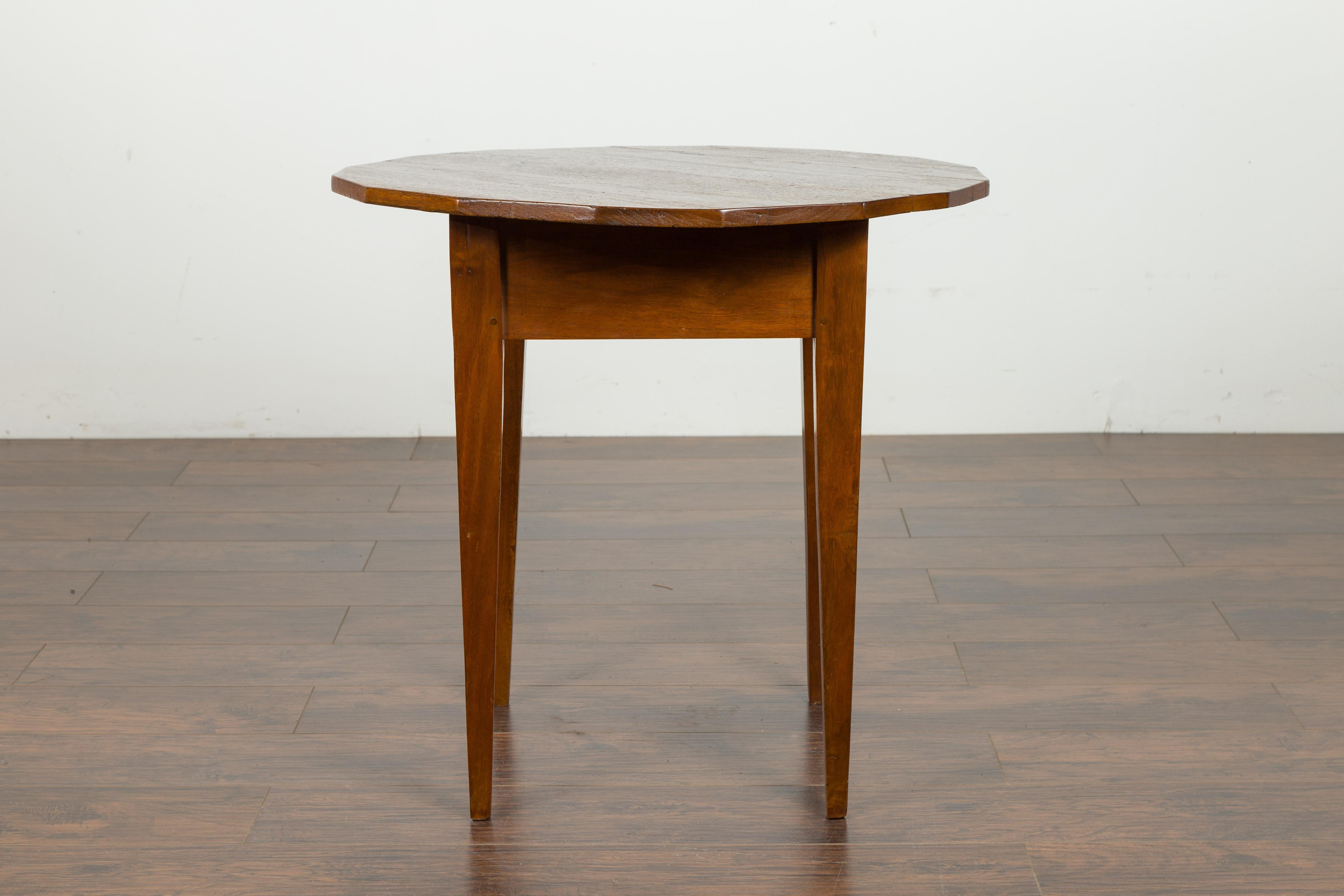 An English walnut side table from the mid-19th century, with polygonal top and tapered legs. Created in England during the third quarter of the 19th century, this side table features a polygonal top resting above a square-shaped apron. The table is
