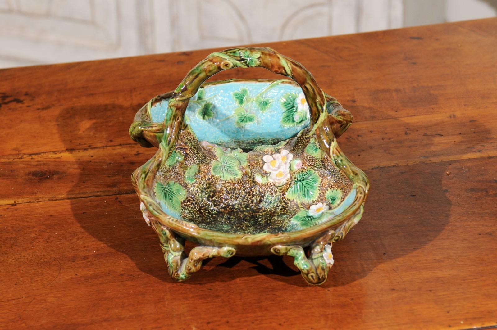 An English mottled brown, green and turquoise Majolica strawberry basket from the late 19th century, signed George Jones. Born in England during the second half of the 19th century, this exquisite Majolica piece features a lovely palette made of