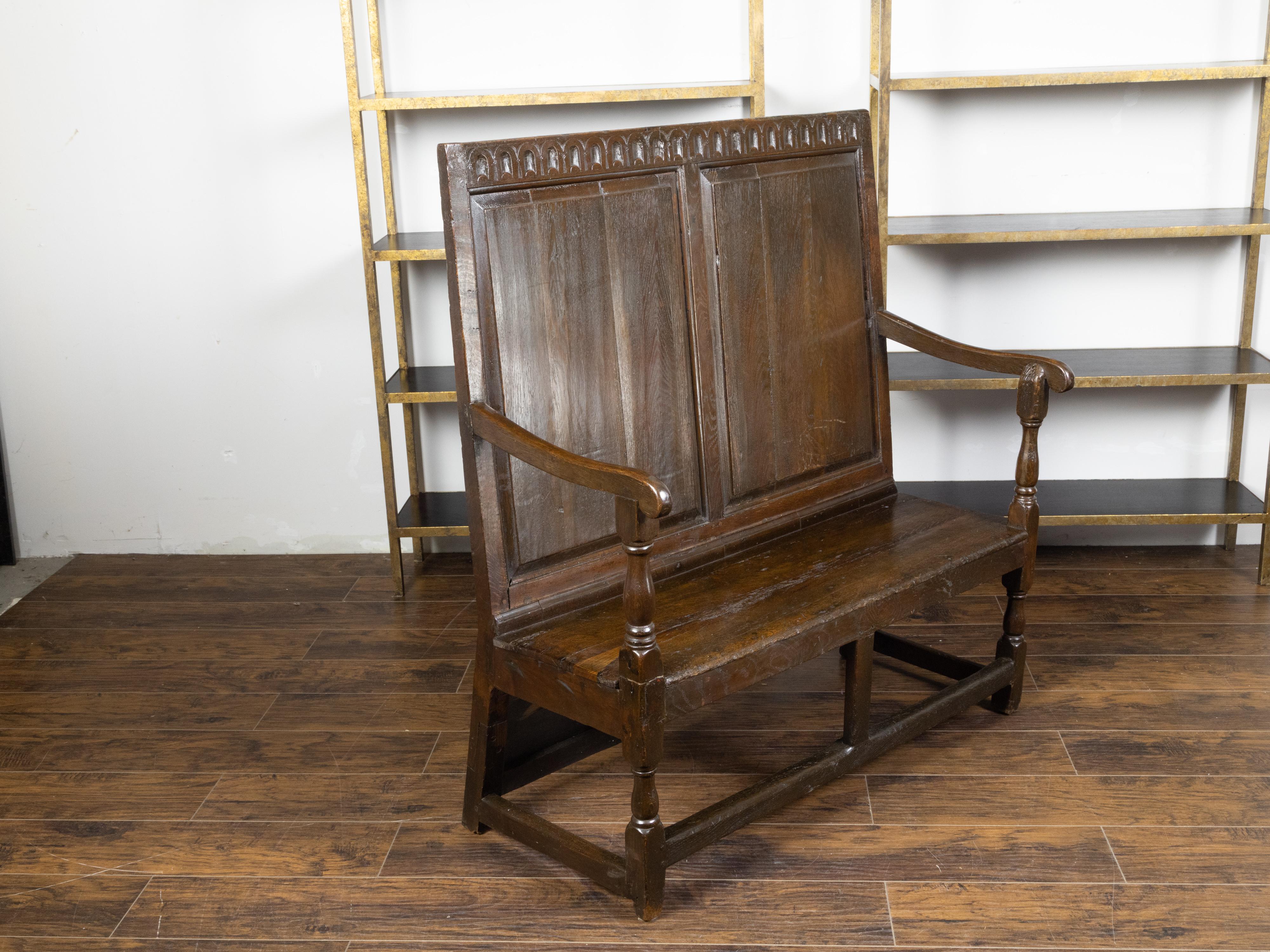19th Century English 1870s Oak Bench with Carved Frieze, Scrolling Arms and Turned Legs