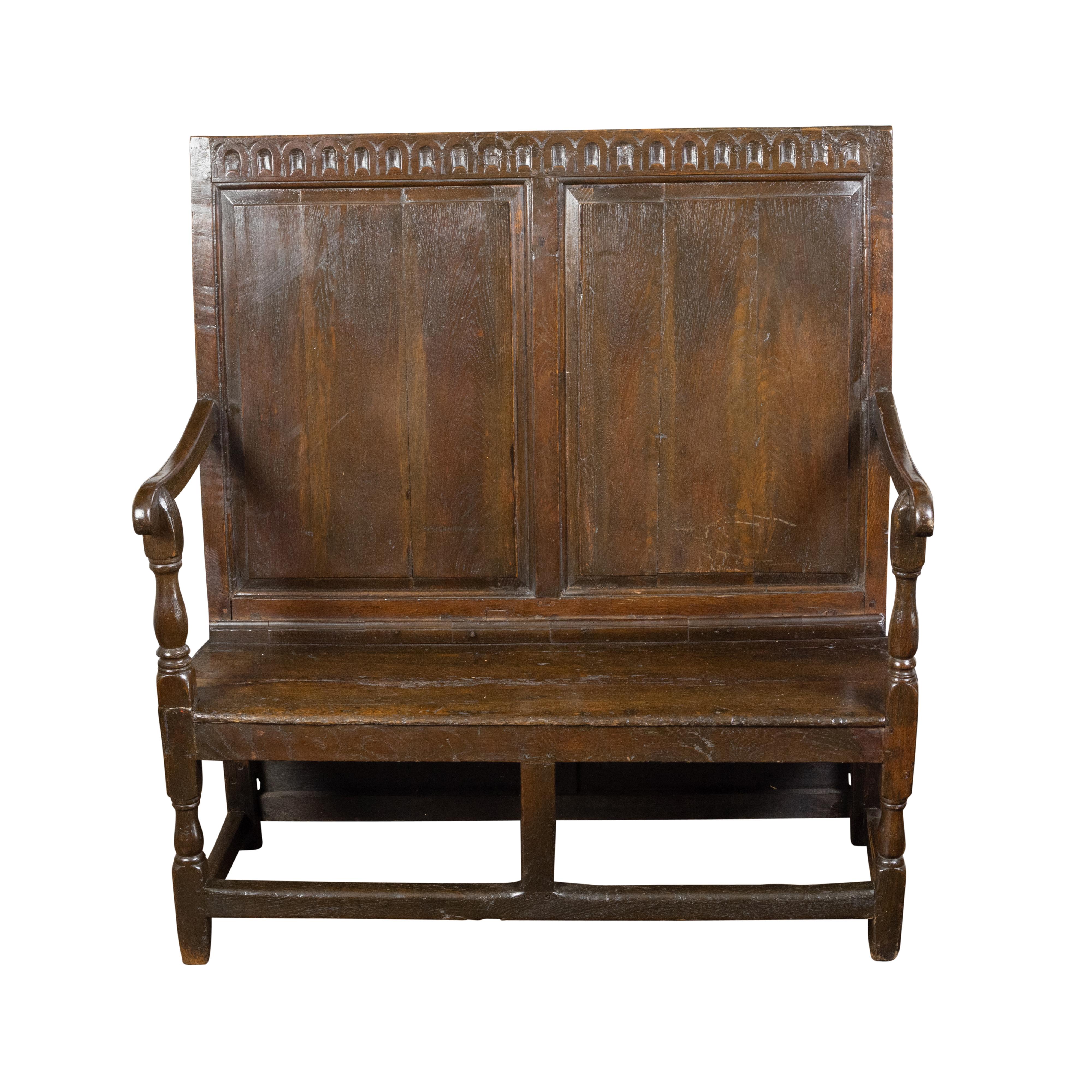 English 1870s Oak Bench with Carved Frieze, Scrolling Arms and Turned Legs