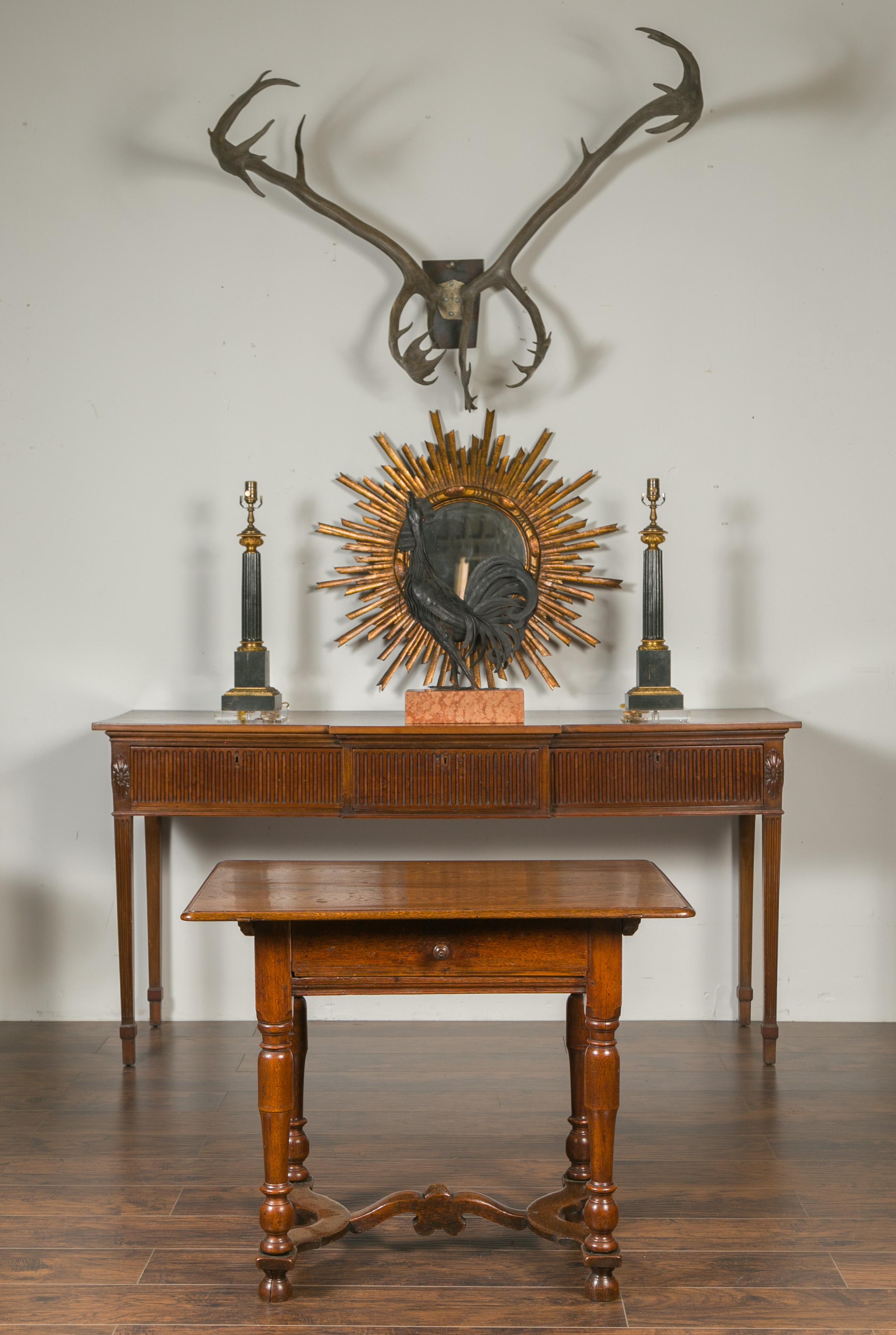 An English oak side table from the late 19th century with single drawer, turned legs and cross stretcher. Born in England during the third quarter of the 19th century, this oak side table features a rectangular top with rounded edges, sitting above