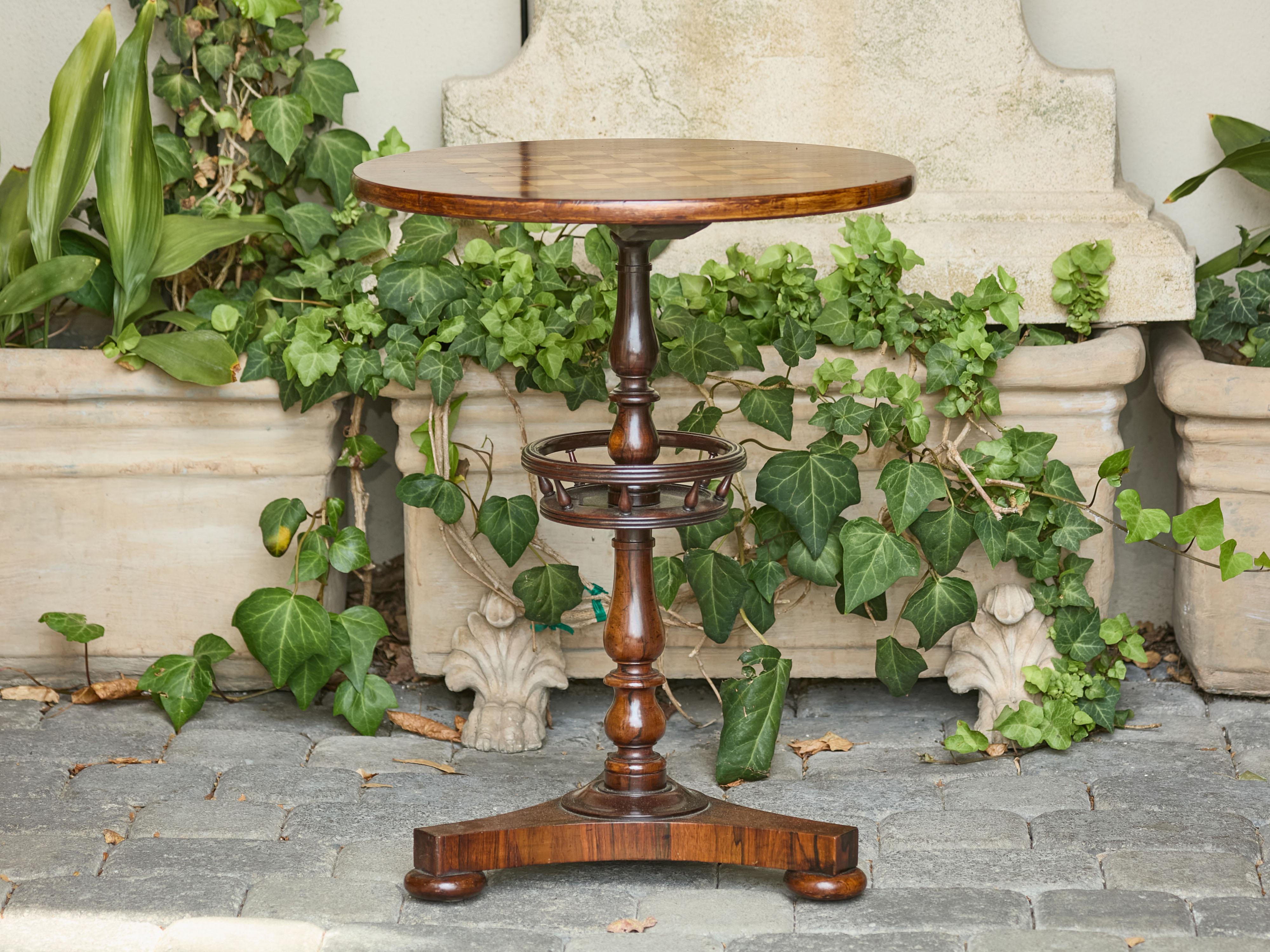 Tavolo da gioco inglese in palissandro guéridon del 1870 circa con piano intarsiato a scacchiera e base a piedistallo. Questo squisito tavolo da gioco inglese in palissandro guéridon, risalente al 1870 circa, presenta un piano circolare,