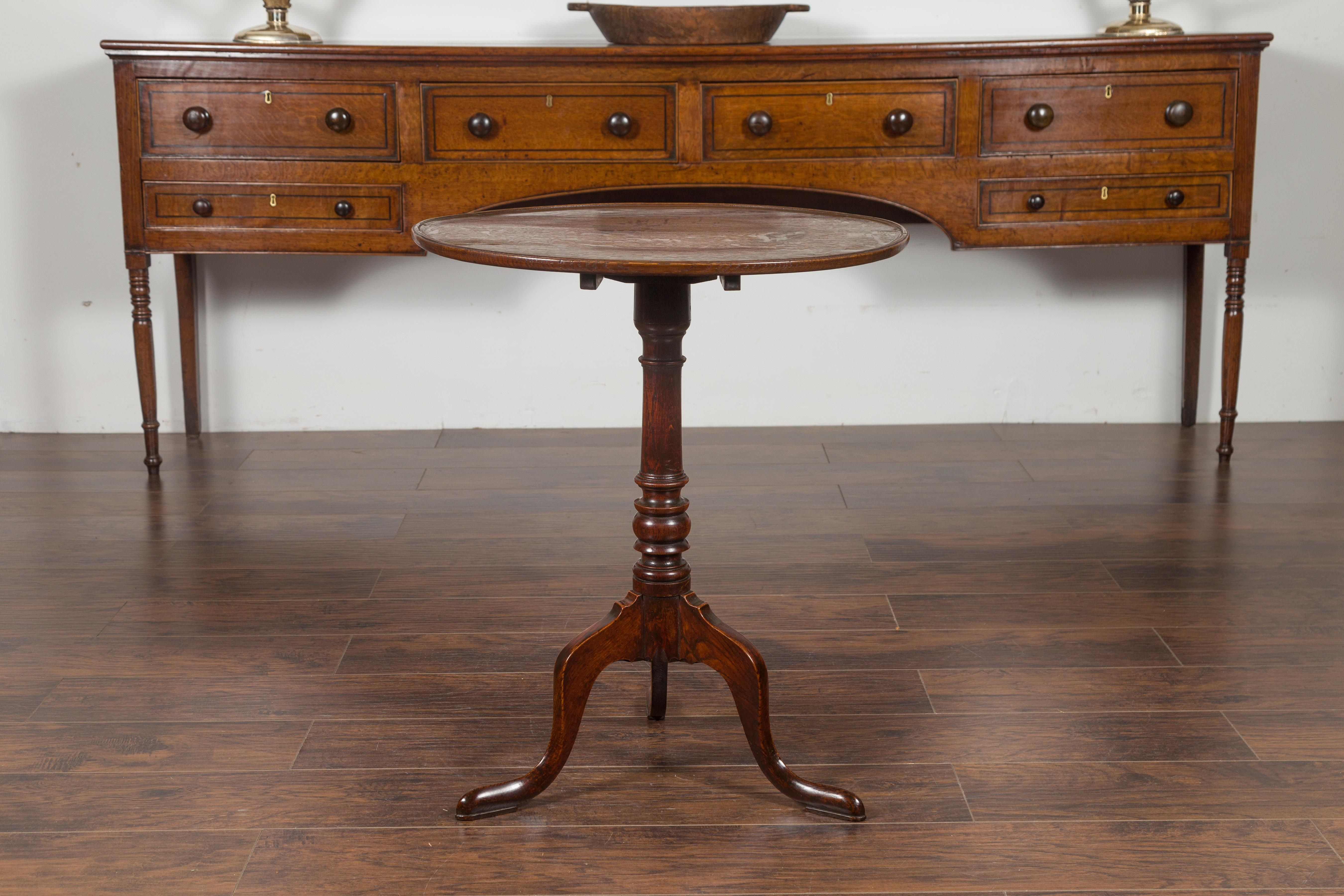 An English tilt-top oak gueridon table from the late 19th century, with tripod base. Created in England during the this quarter of the 19th century, this oak table features a circular tilt-top sitting above a pedestal resting on a tripod base.