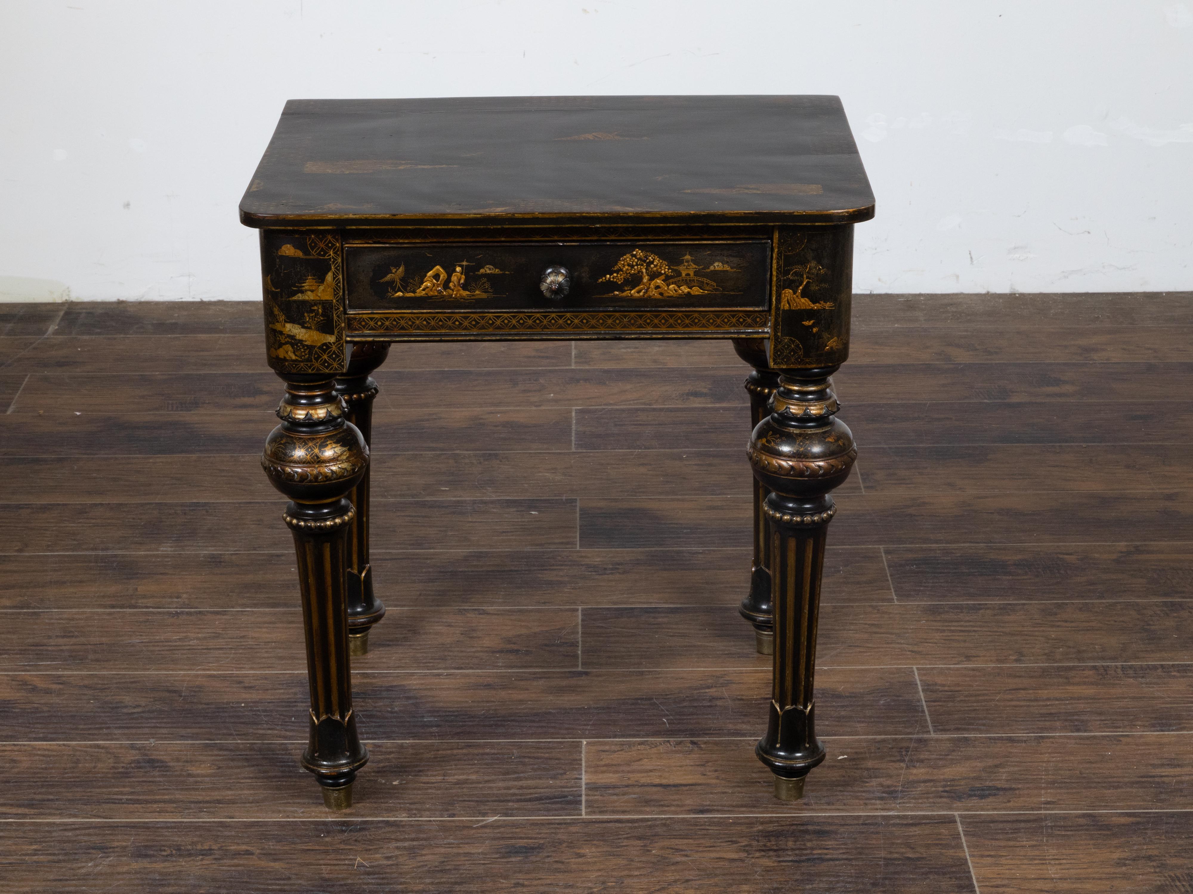 An English black and gold japanned side table circa 1880 with Chinoiserie décor depicting architectures in landscapes, birds, trees and flowers, with single drawer and turned fluted legs. This English black and gold japanned side table, dating back