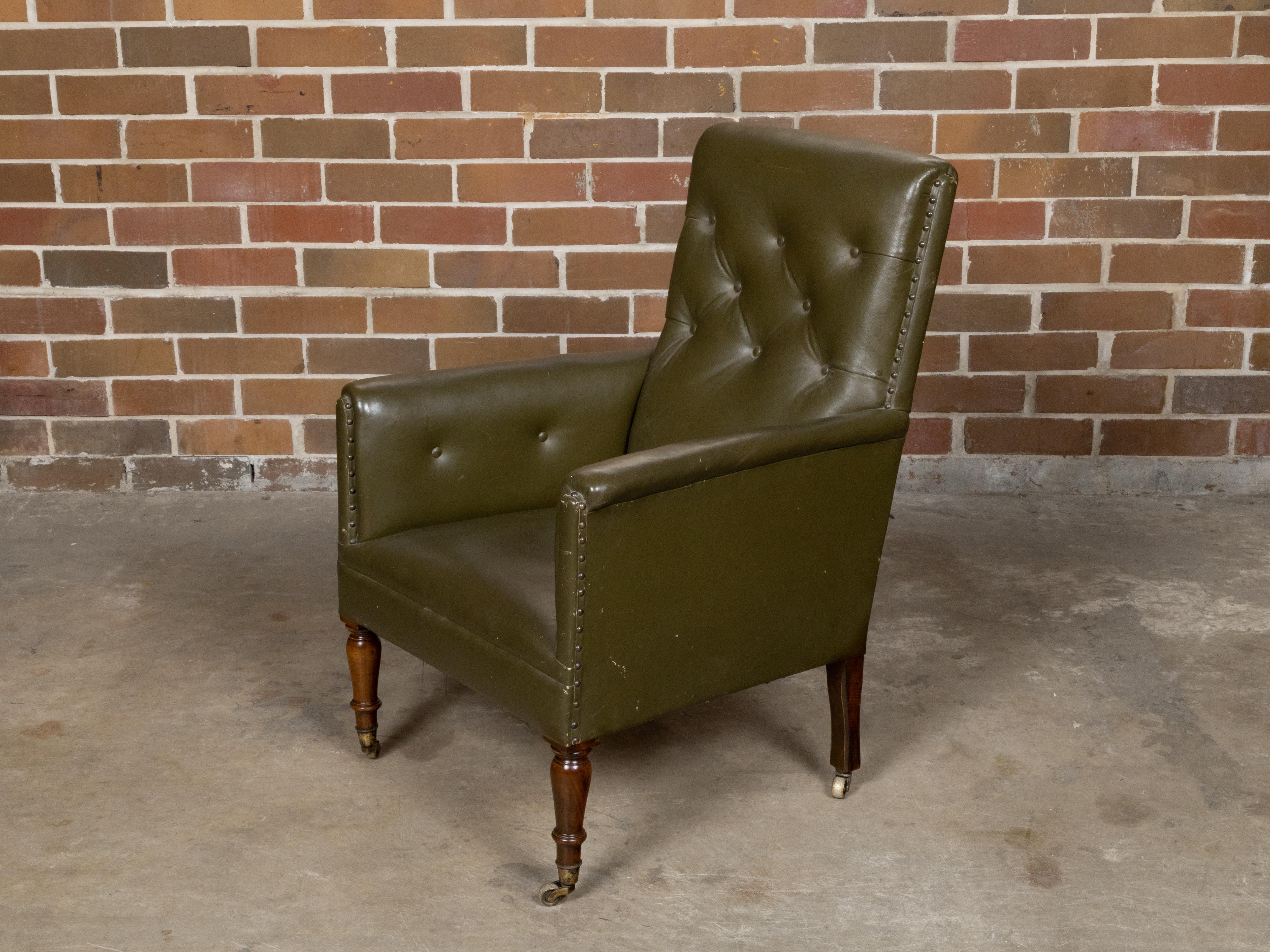 An English green tufted leather armchair from circa 1880 with turned legs and casters. Born in England circa 1880, this green tufted leather armchair features a tufted back and smooth seat, showcasing the luxurious green leather that, over time, has