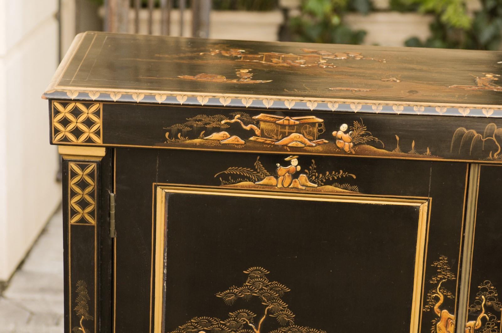 An English Japanned black buffet from the late 19th century, with hand painted chinoiserie decor. Born in the later years of the 19th century, this narrow two-door black colored buffet features a rectangular top with beveled edges, sitting above two