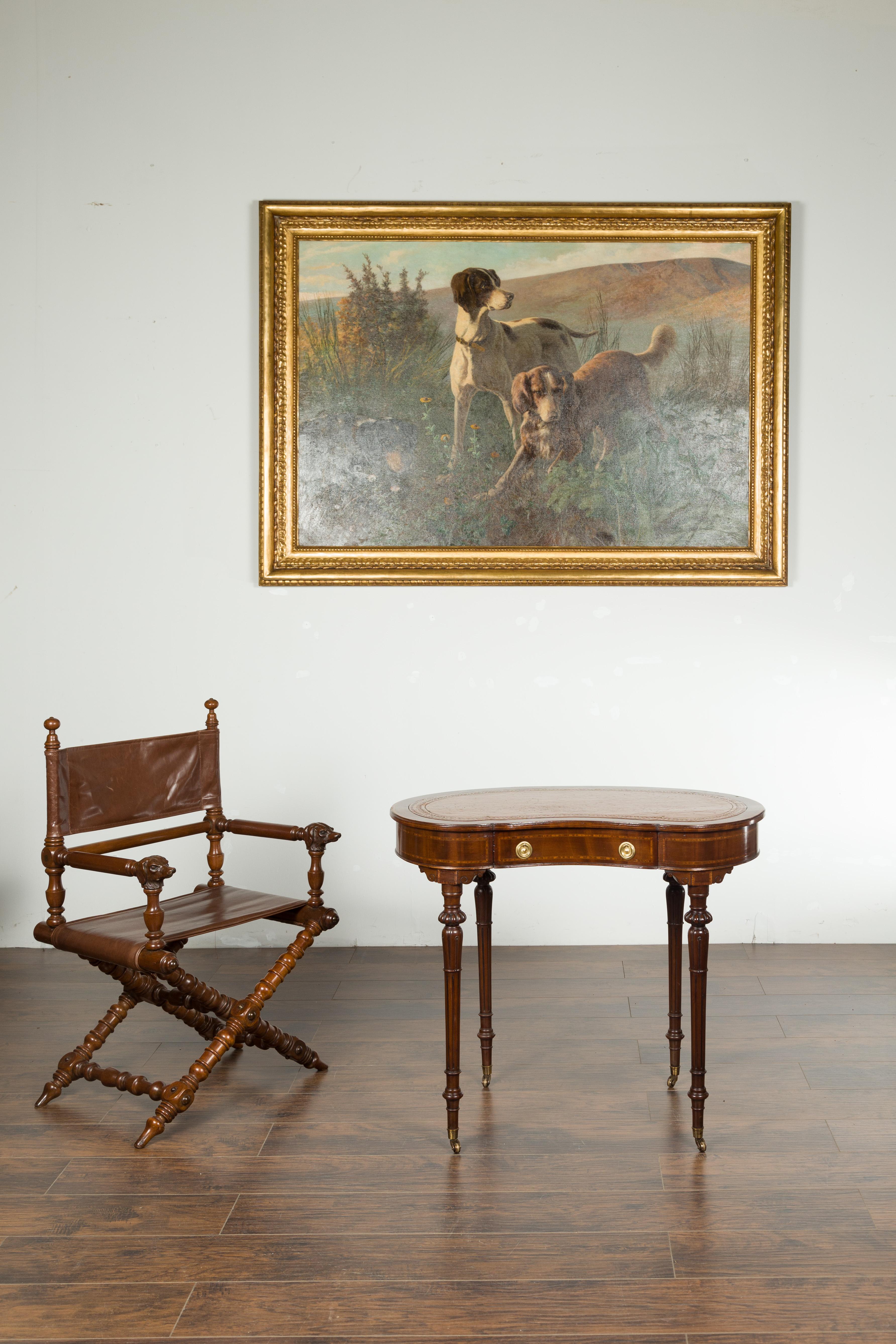 An English mahogany kidney table from the late 19th century, with leather top, banding and casters. Created in England during the last quarter of the 19th century, this mahogany kidney table features a shaped leather top sitting above a single