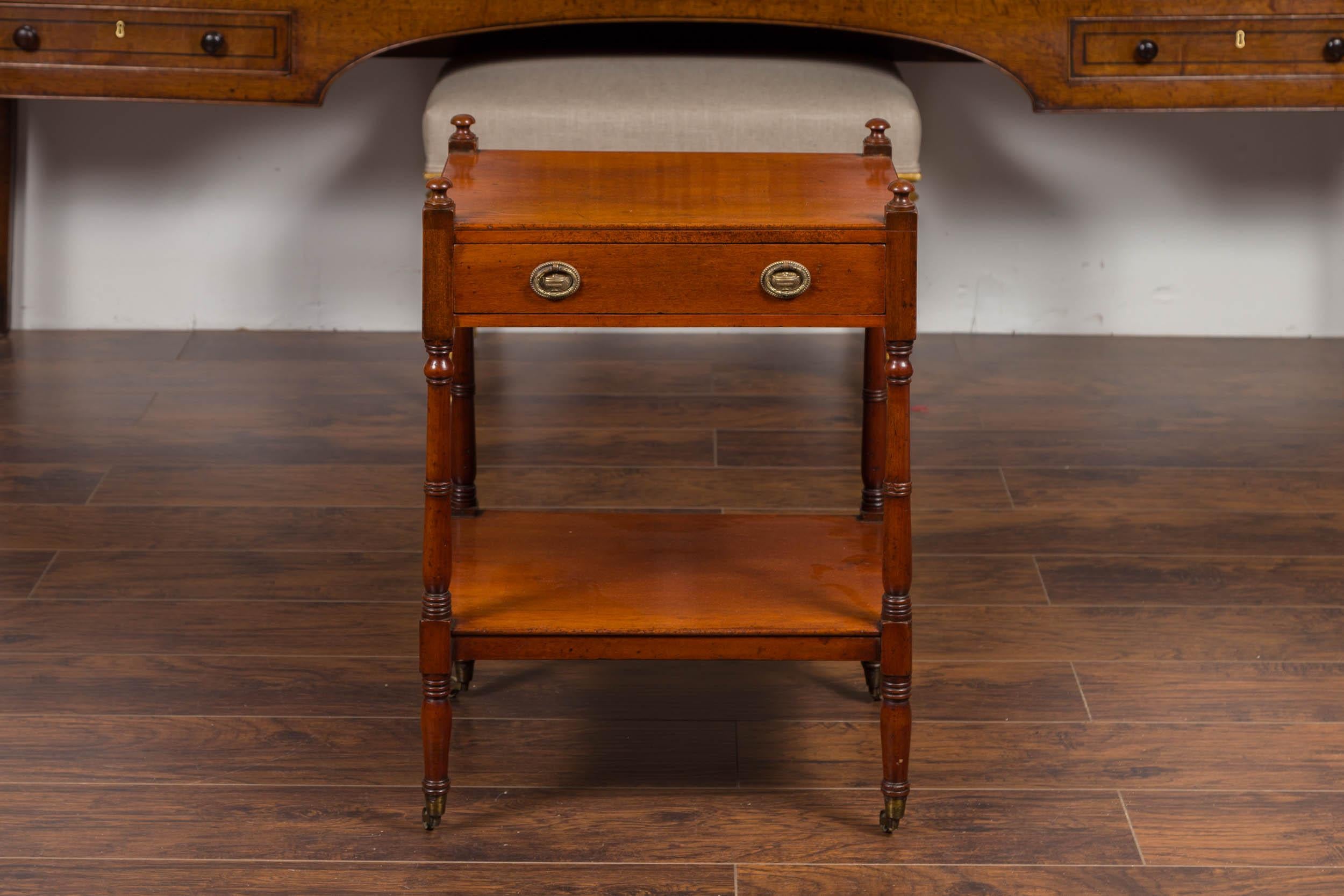 An English mahogany trolley from the late 19th century, with single drawer, lower shelf and casters. Born in England during the last quarter of the 19th century, this tiered trolley features a rectangular top resting on a single drawer fitted with