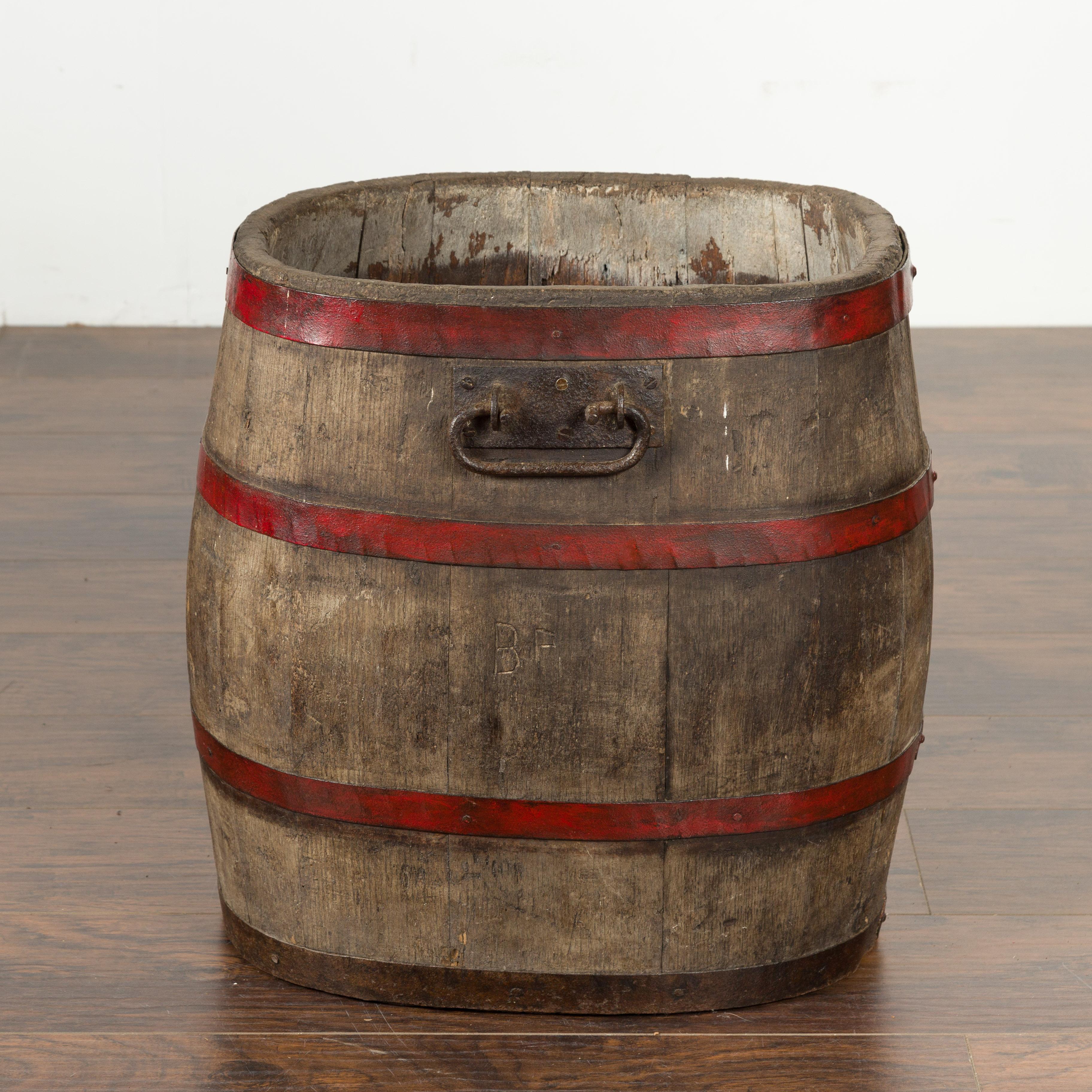 An English rustic oak barrel from the late 19th century, with red braces and weathered patina. Created in England during the last quarter of the 19th century, this barrel charms us with its nice proportions and rustic presence. Accented with red