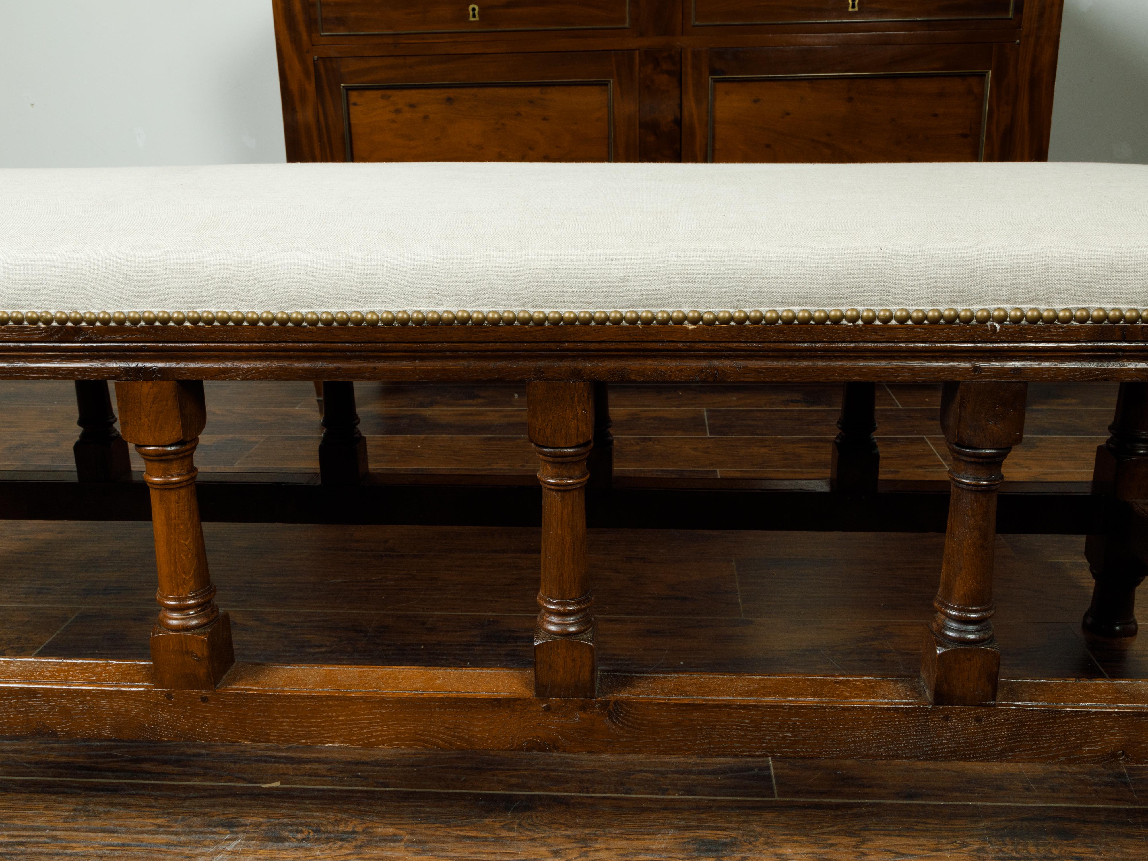 19th Century English 1880s Oak Bench with Turned Legs, Side Stretchers and New Upholstery