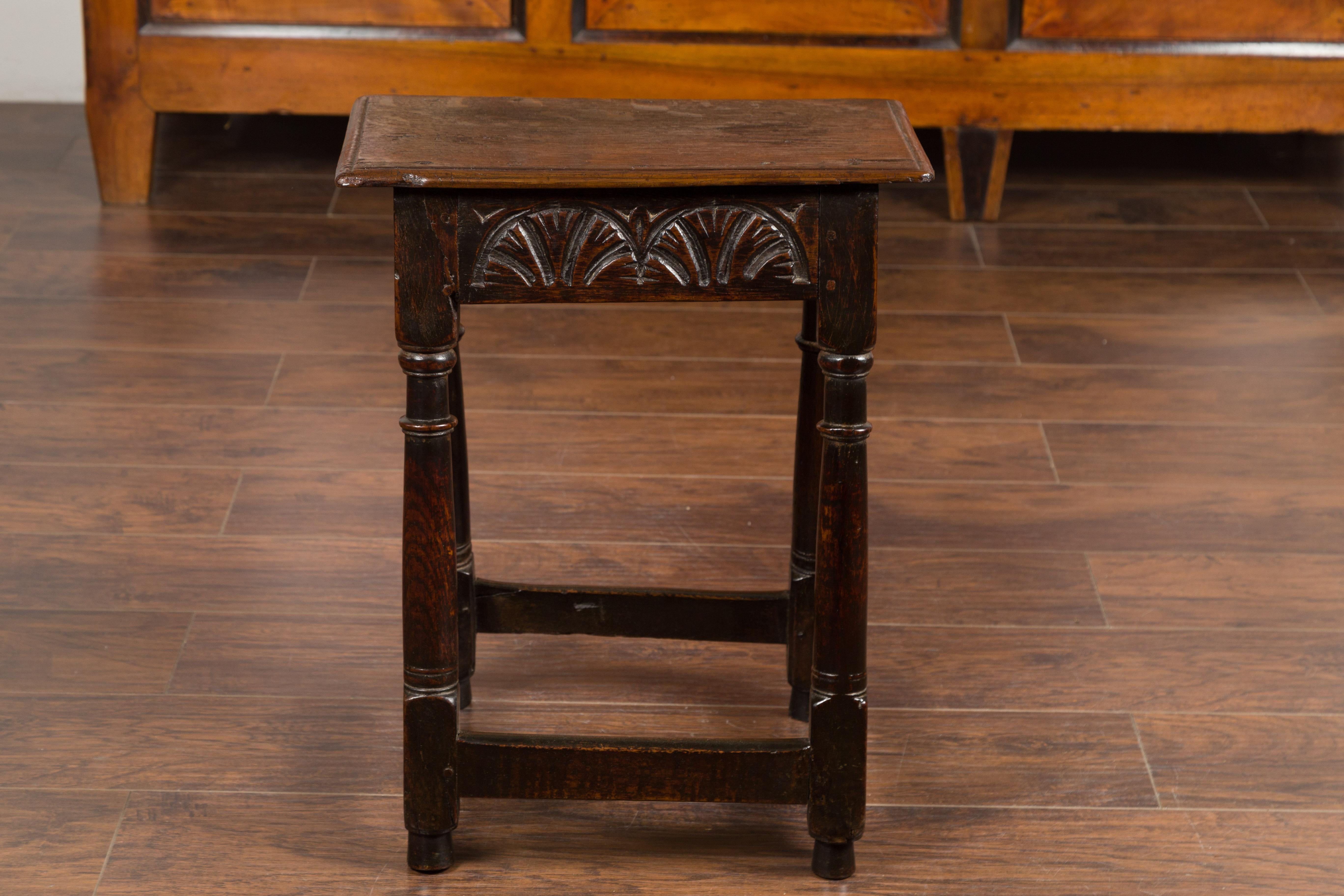 Sgabello inglese in quercia della fine del XIX secolo, con motivi intagliati e gambe tornite. Creato in Inghilterra nell'ultimo quarto del XIX secolo, questo sgabello a incastro in Oak presenta un piano rettangolare che si trova sopra un grembiule