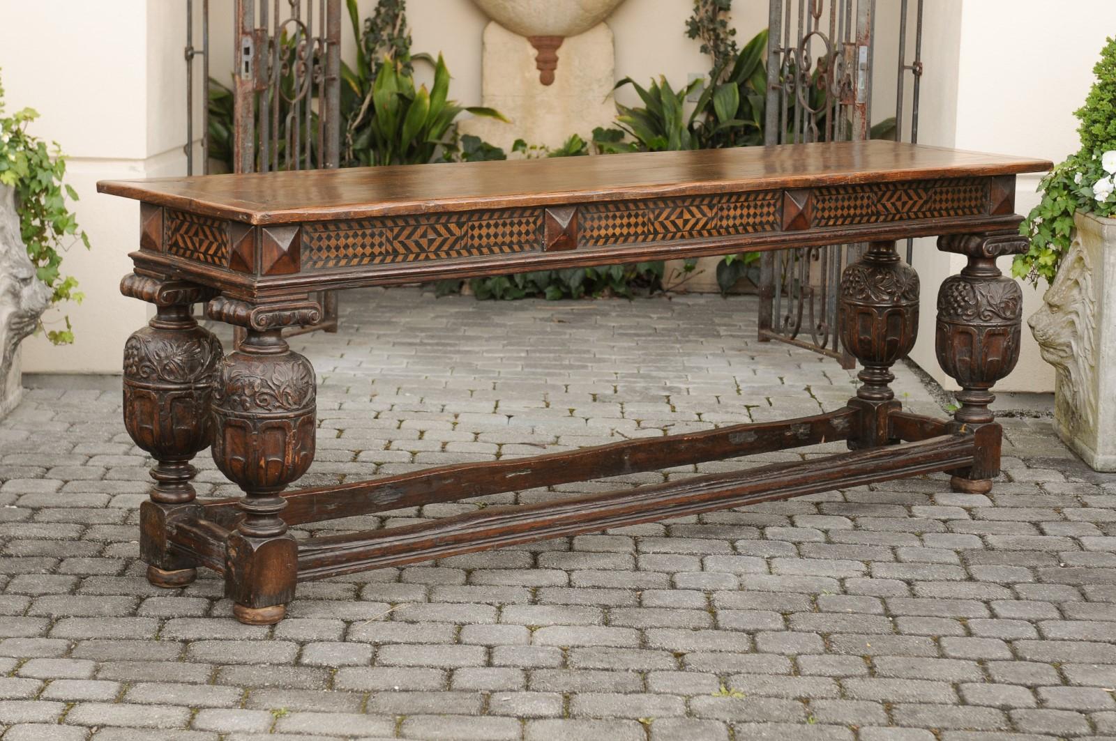 An English oak serving table from the late 19th century, with black geometrical décor and large richly carved baluster legs. Born in England at the end of the 19th century, this exquisite serving table features a rectangular planked top sitting