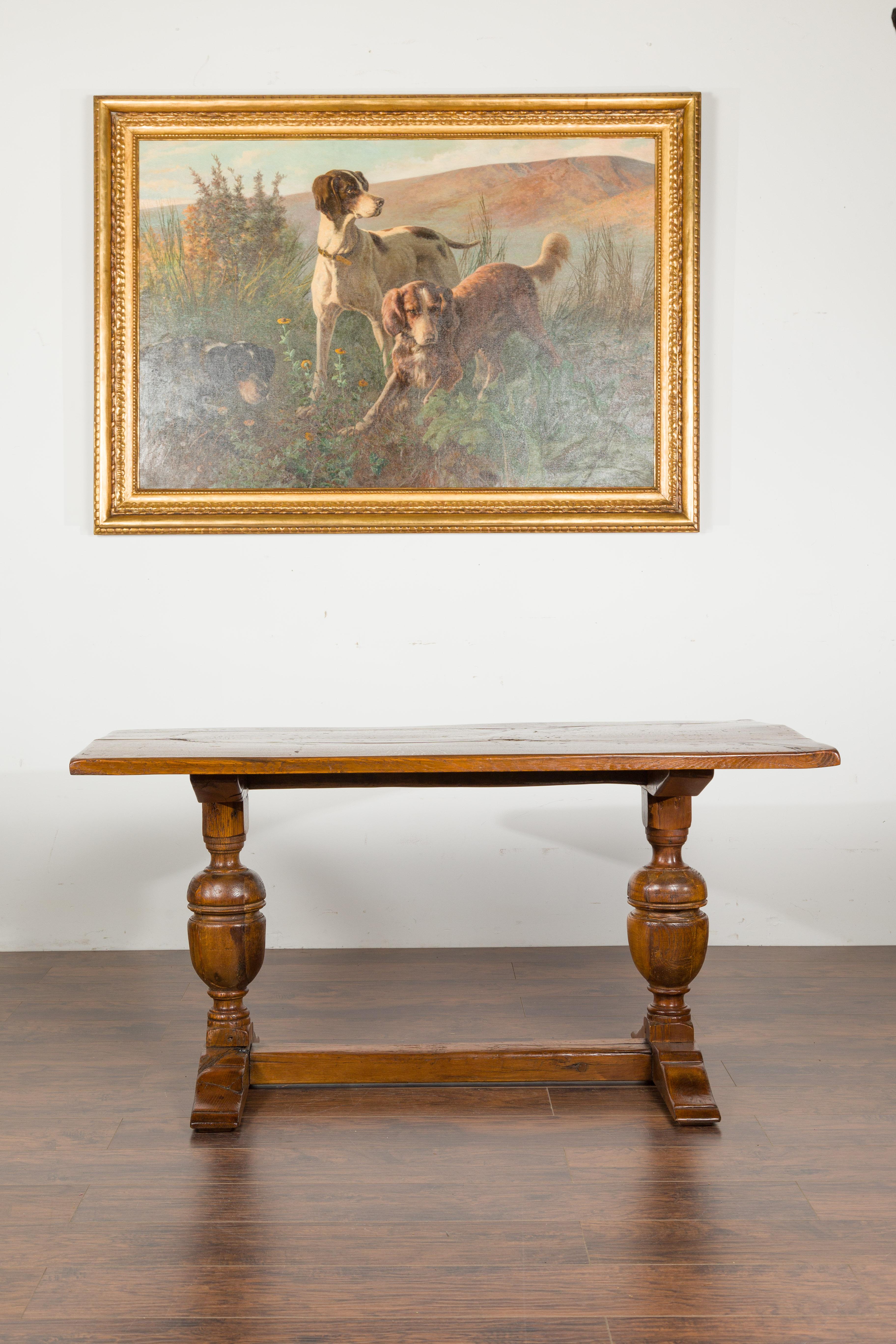 An English oak table from the late 19th century, with large turned legs and cross stretcher. Created in England during the last quarter of the 19th century, this oak table features a rectangular top showcasing a nicely worn appearance, sitting above