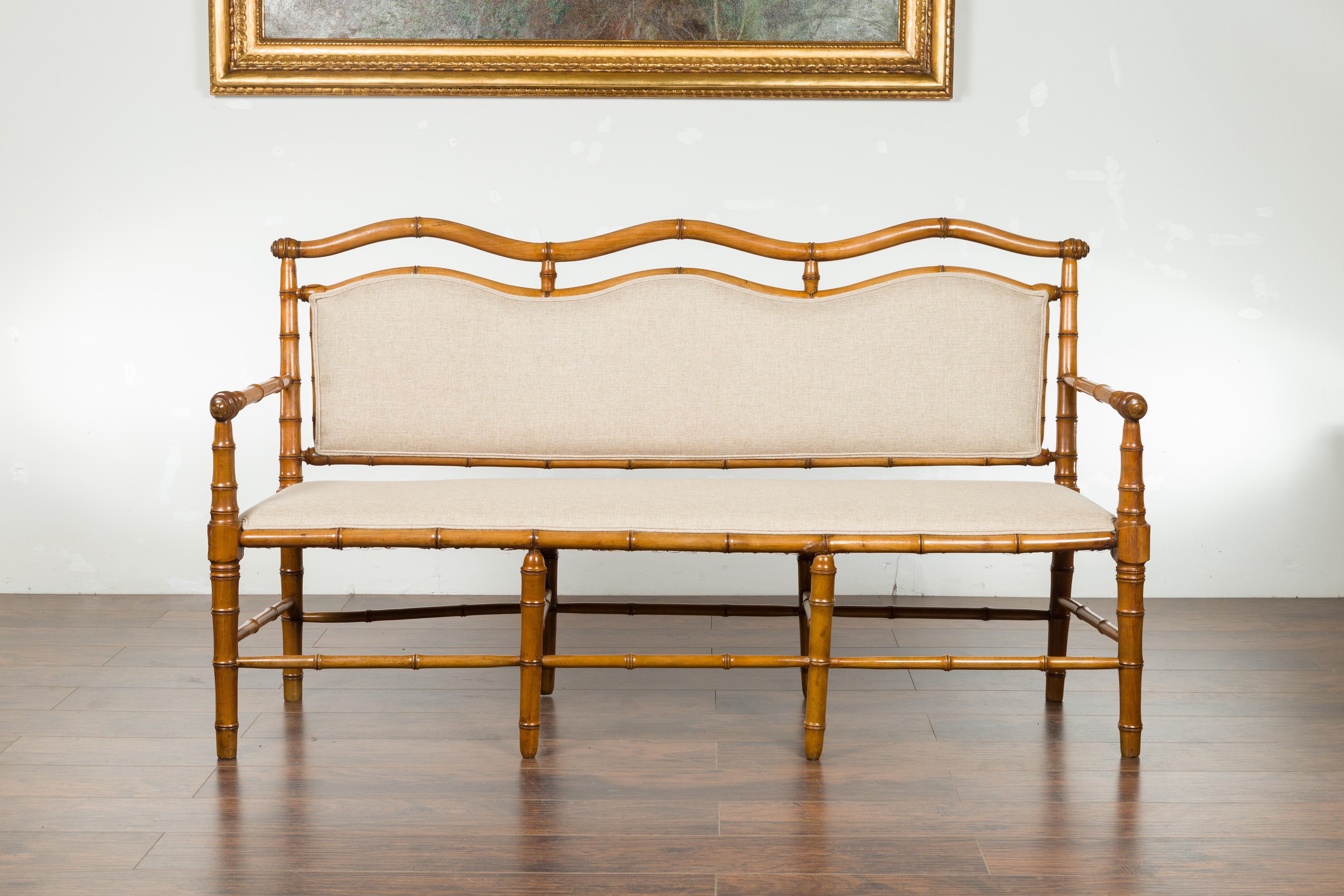 An English walnut faux-bamboo three-seat bench from the late 19th century, with new linen upholstery. Created in England during the last quarter of the 19th century, this walnut bench features a faux bamboo structure perfectly complimented by a new