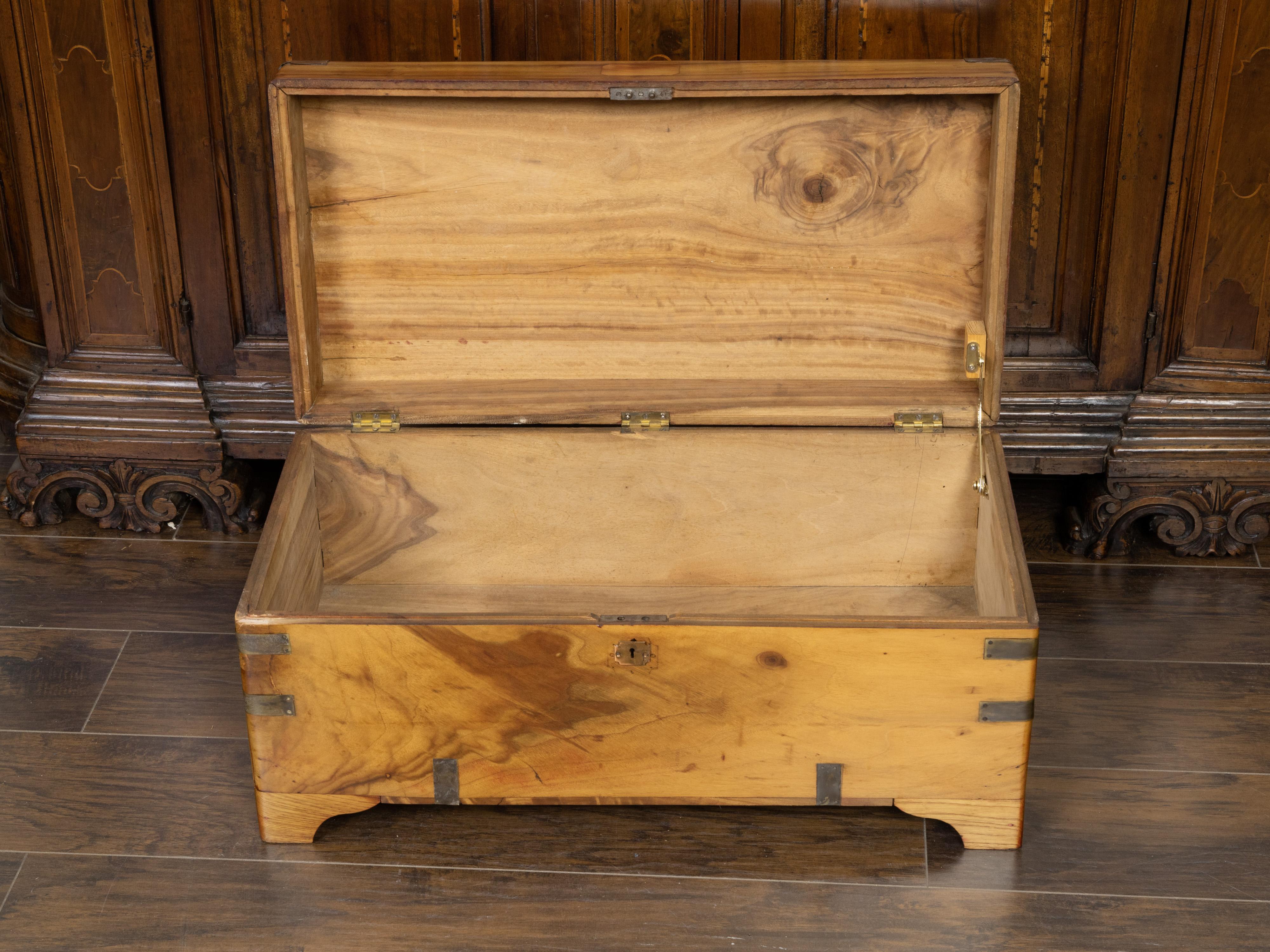 An English camphor wood trunk from the late 19th century with brass accents. Created in the last decade of the 19th century, this English camphor wood trunk presents an elegant linear silhouette, beautifully accented with brass details. The