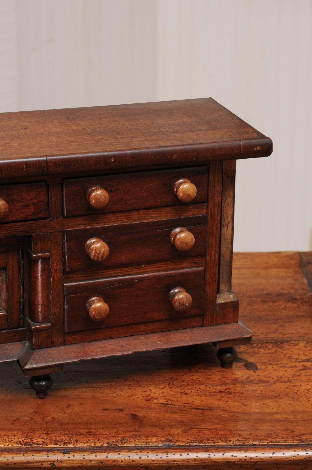 Wood English 1890s Miniature Chest with Seven Drawers, Semi Columns and Turnip Feet