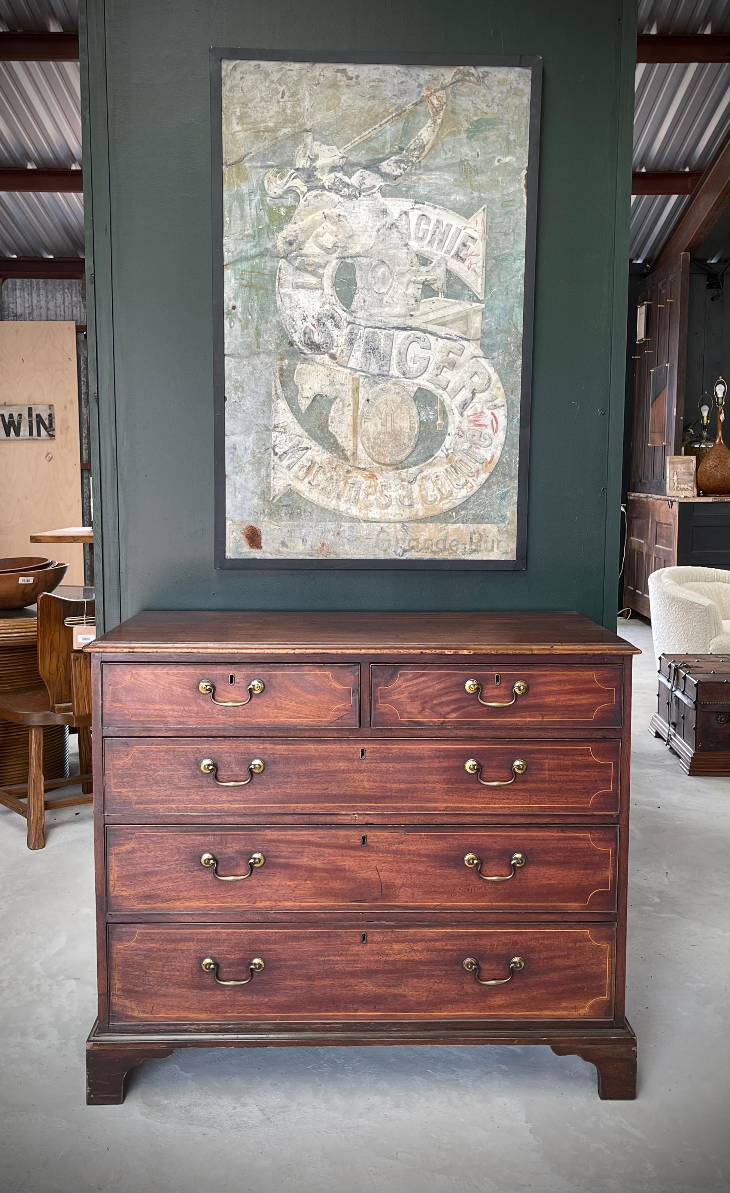 Transport yourself back in time with this remarkable English late 18th-century Georgian chest of drawers. Constructed with care, it embodies the essence of meticulous English traditional craftsmanship. Adorned with intricate mahogany inlay detailing
