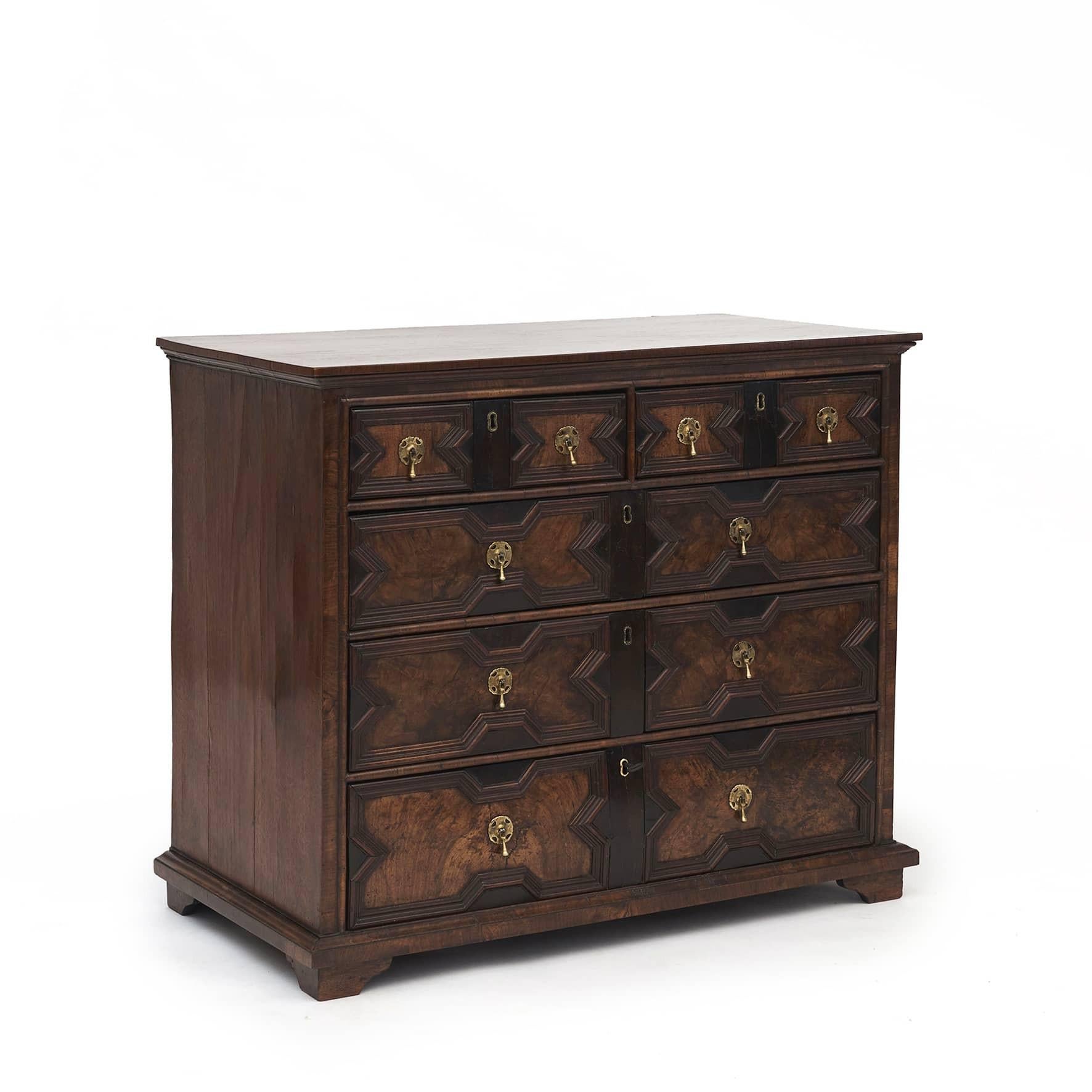 English walnut and oak Jacobean chest of drawers.
With five drawers: two smaller drawers at the top and three larger drawers below. Oak and ebony paneling and molding to all drawer fronts. Drawer bottoms i walnut. Top and sides in