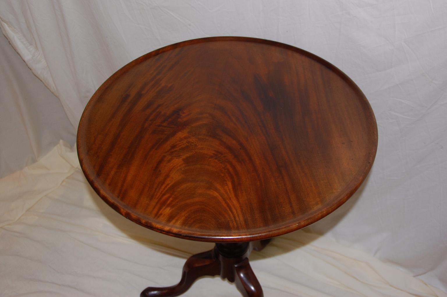 English 18th century Georgian Chippendale mahogany dishtop, tilt top tripod table. This table has a one board flame grain mahogany top that has been carved out to form a dishtop; the carved mahogany cabriole legs end in pad feet, the stem is