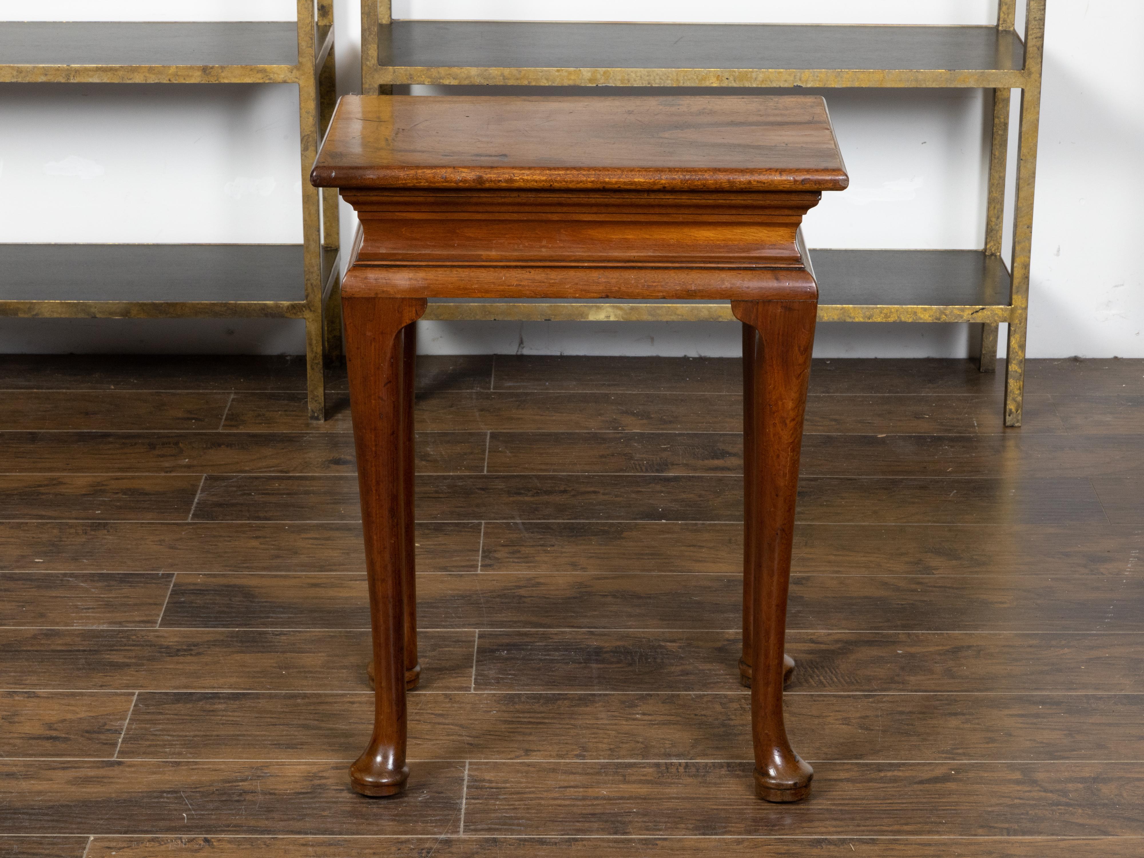 An English Georgian period walnut console table from the 18th century, with molded apron and pad feet. Created in England during the Georgian period in the 18th century, this walnut console table features a rectangular single plank top with nicely
