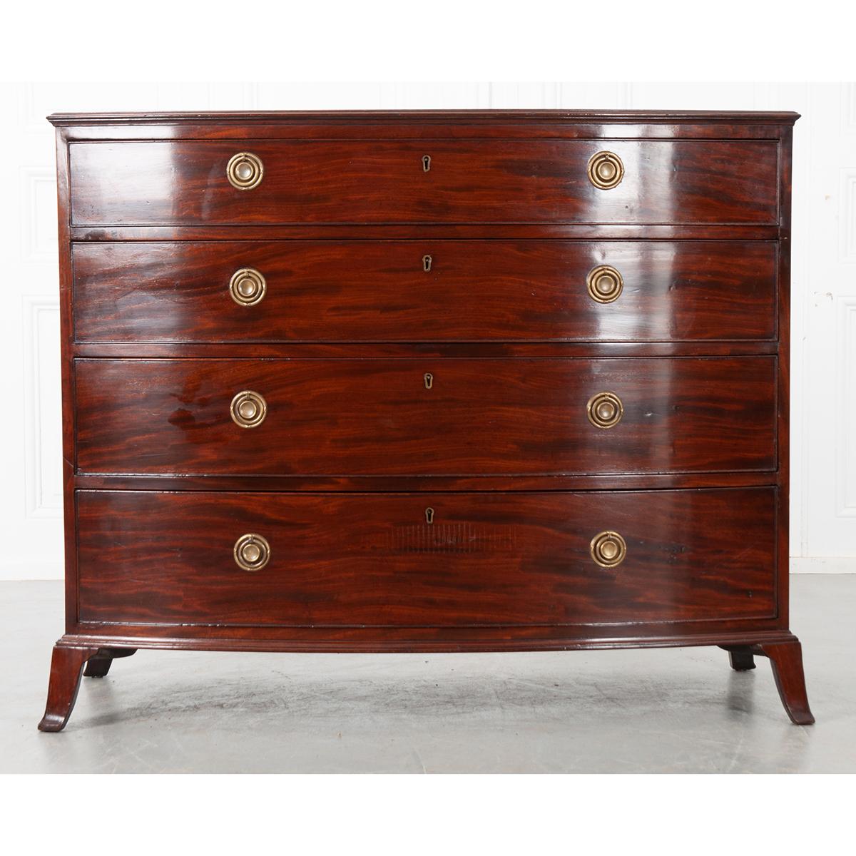 This is a lovely English 18th century mahogany chest with a bow front. It has a wonderful patina from years of loving care and use. The top sits over four drawers with two round brass pulls on each drawer. All sit atop four splayed legs. Circa