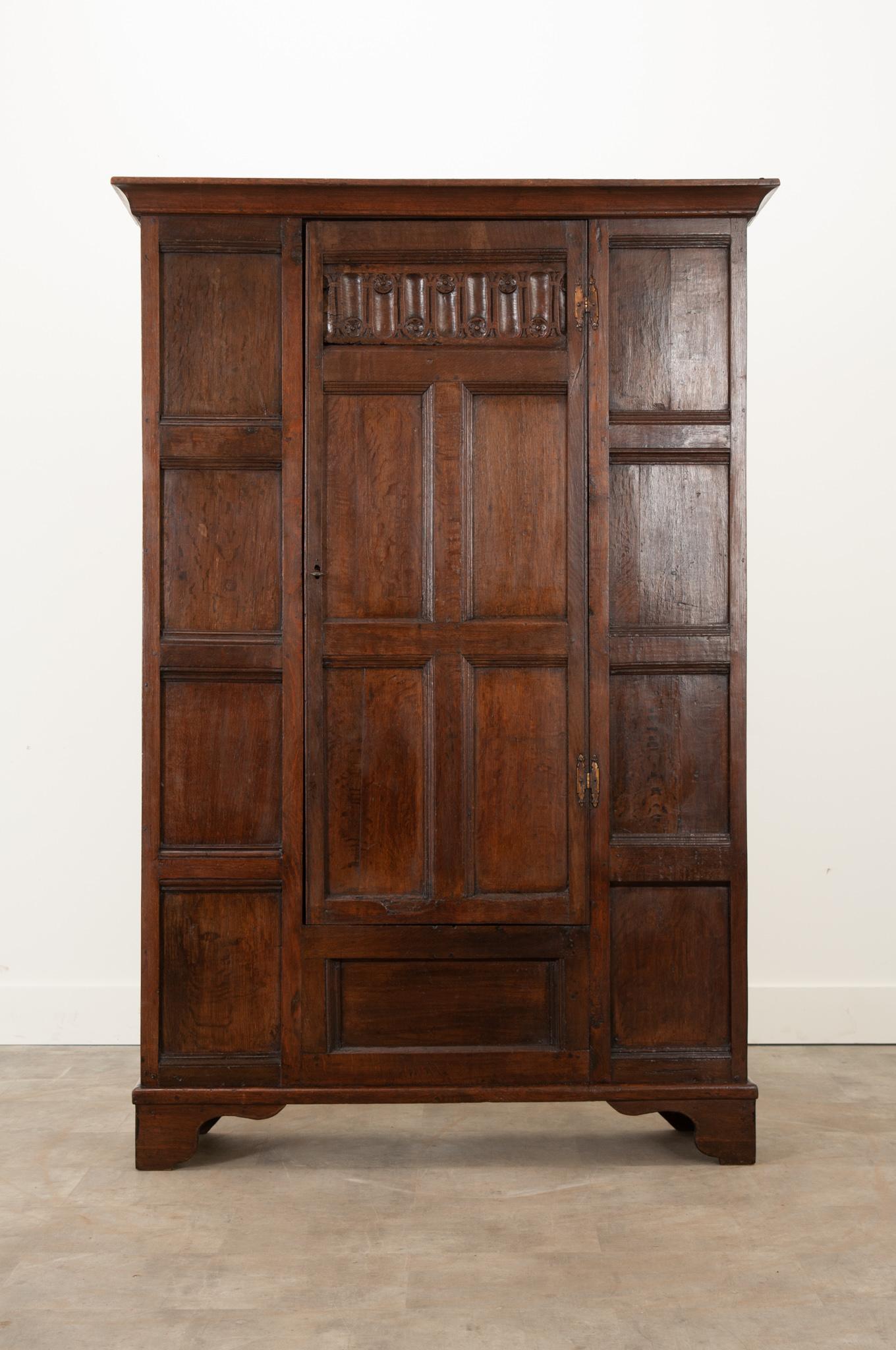 This wonderfully carved solid oak cabinet was crafted in the 1700s with style and functionality in mind. Thumbnail molded paneling on the front and sides give it fantastic depth. The door is carved with four panels below a rosette motif inspired by
