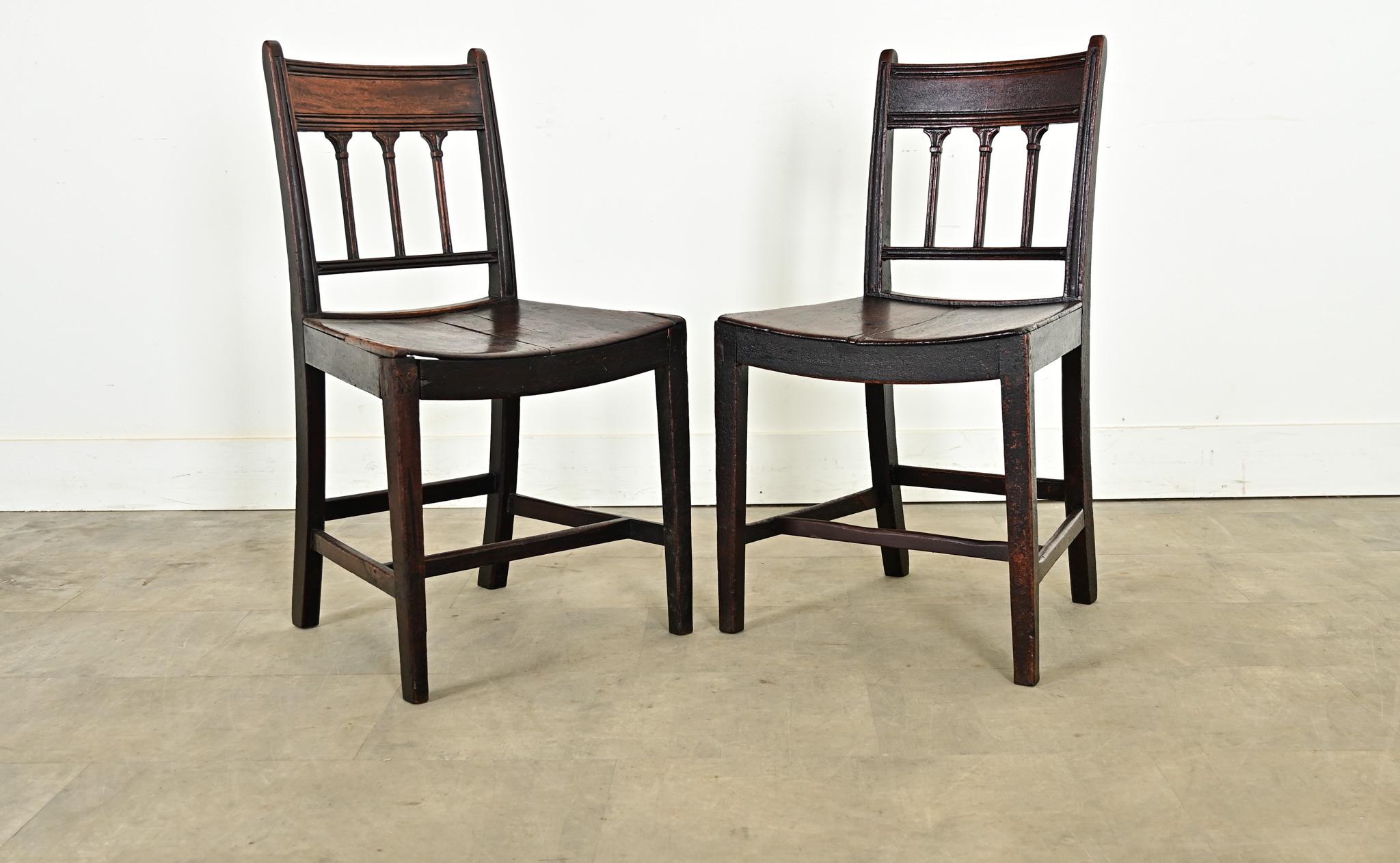 Une belle paire de chaises en chêne sculpté de style George III datant du 18ème siècle. Regardez de près pour apprécier les cannelures élégamment sculptées sur le dossier du siège et la façon dont elles imitent la silhouette des colonnes