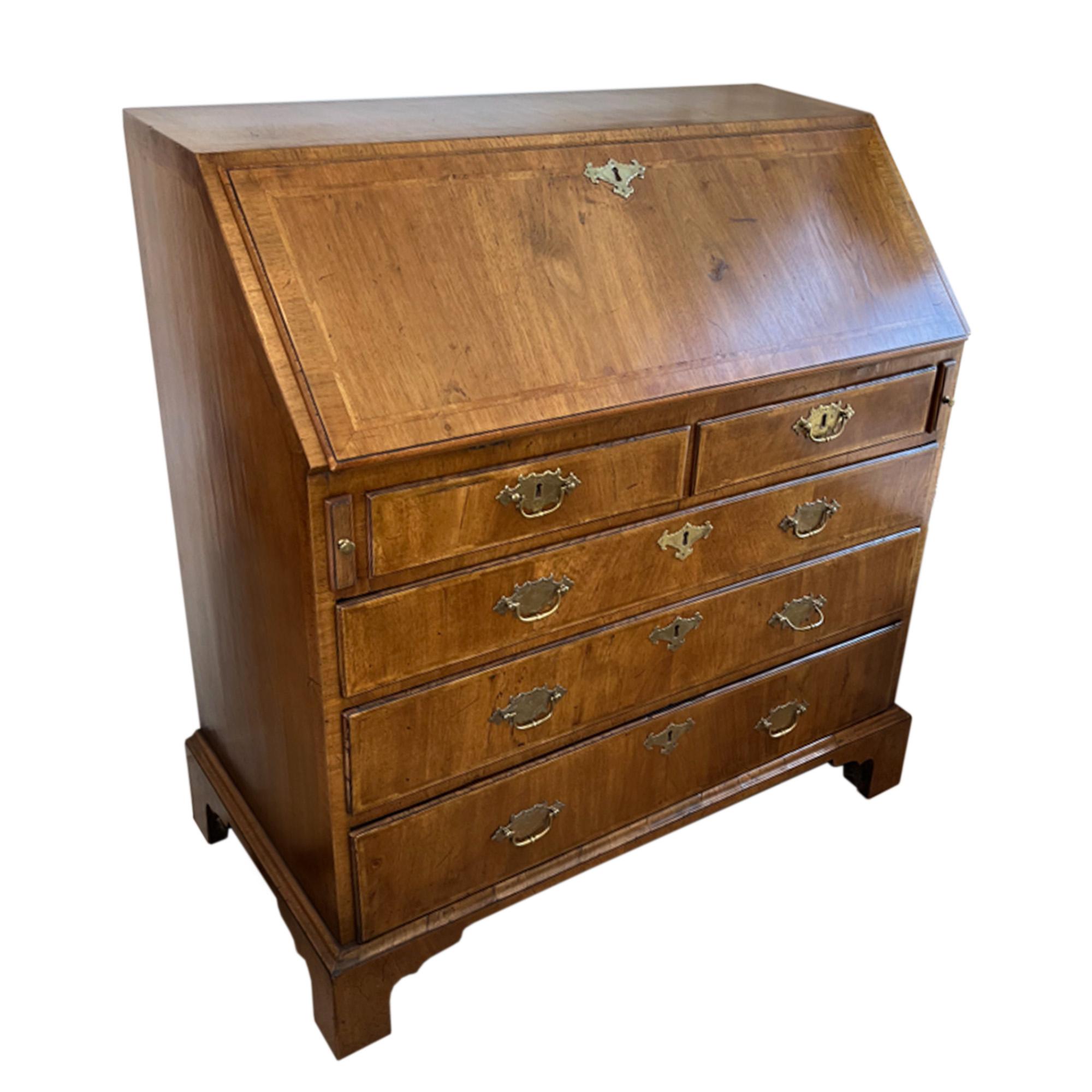 This elegant desk was made in England in the 18th century.

Crafted from walnut, it has a lovely patina.

This piece offers great storage, with several drawers and compartments inside for organisation. The main section has 3 large and 2 smaller