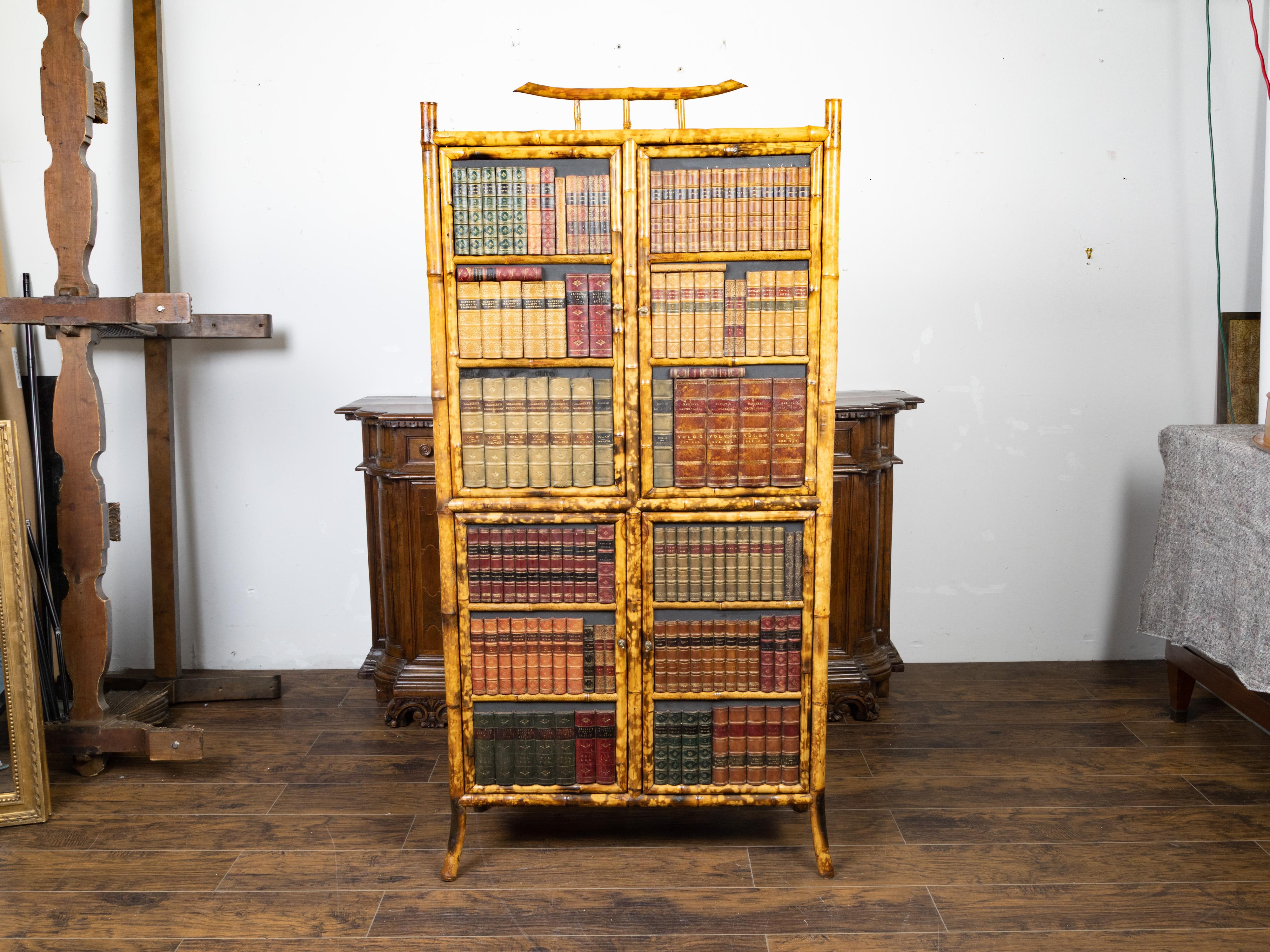 An English bamboo cabinet from the early 20th century, with faux books façade. Created in England during the early years of the 20th century, this cabinet features a bamboo structure surrounding two doors adorned with a handsome faux book décor.