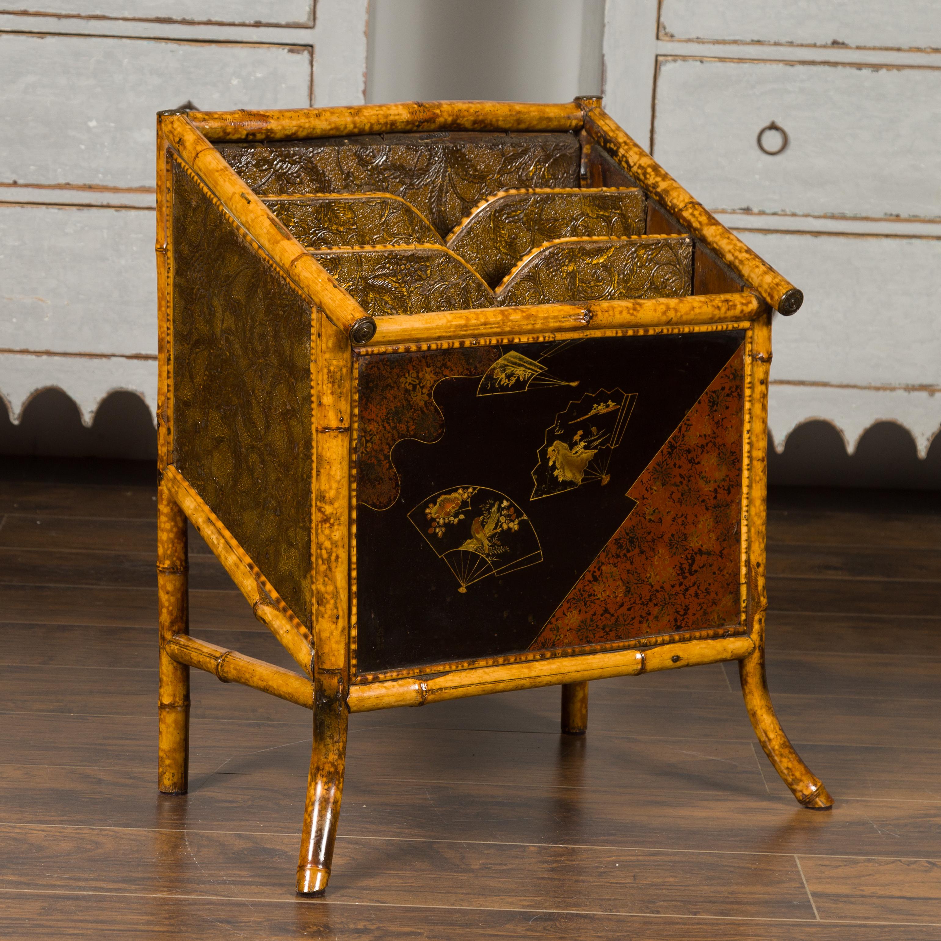 An English bamboo Canterbury from the early 19th century, with embossed leather and Chinoiserie motifs. Born in England at the turn of the century, this handsome magazine rack features a bamboo structure securing embossed leather partitions. Adorned