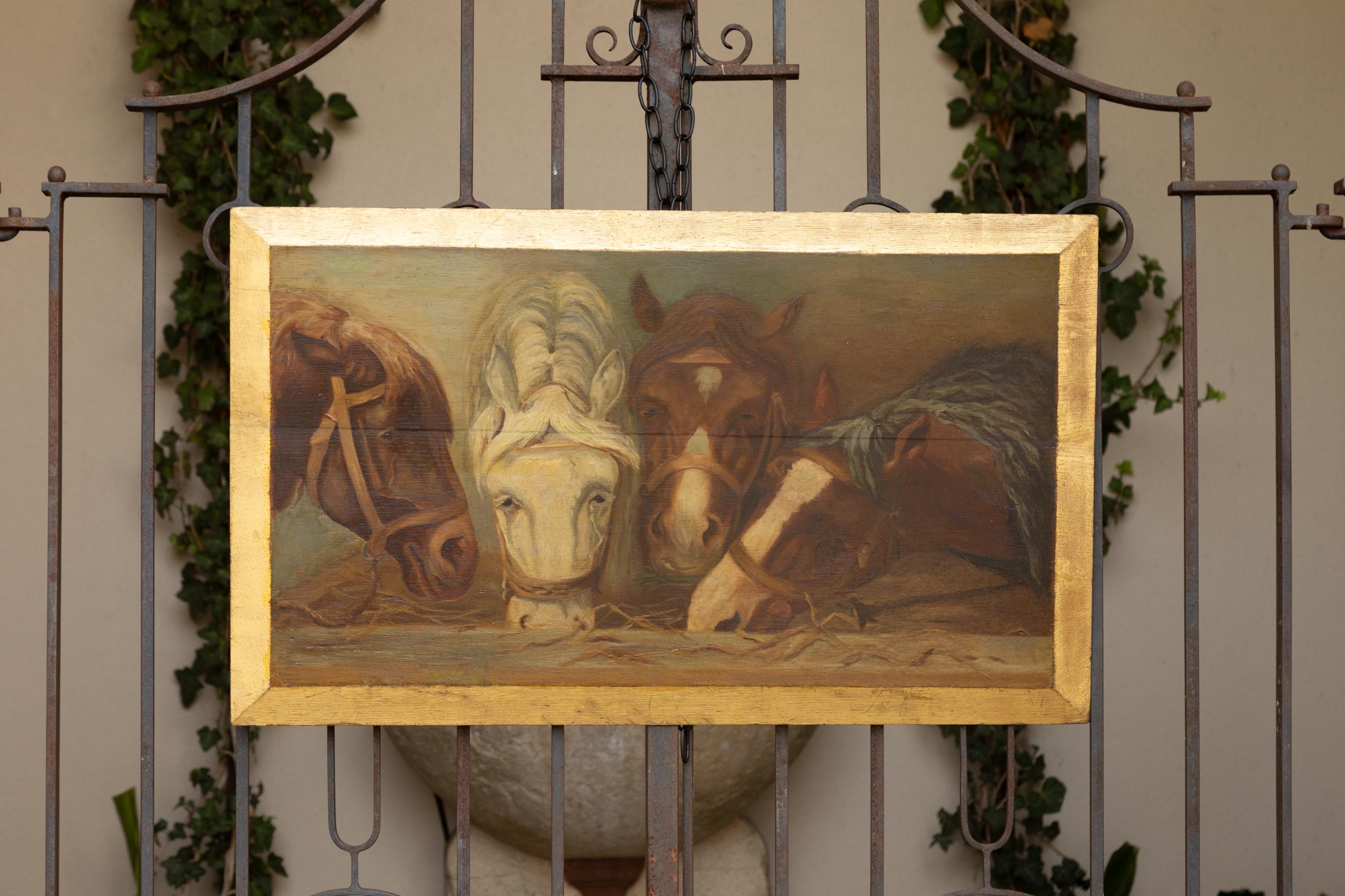 An English oil on board horse painting from the early 20th century, with gilt painted border. Born in England during the early years of the 20th century, this horizontal painting attracts our attention with its four horses depicted in a close view
