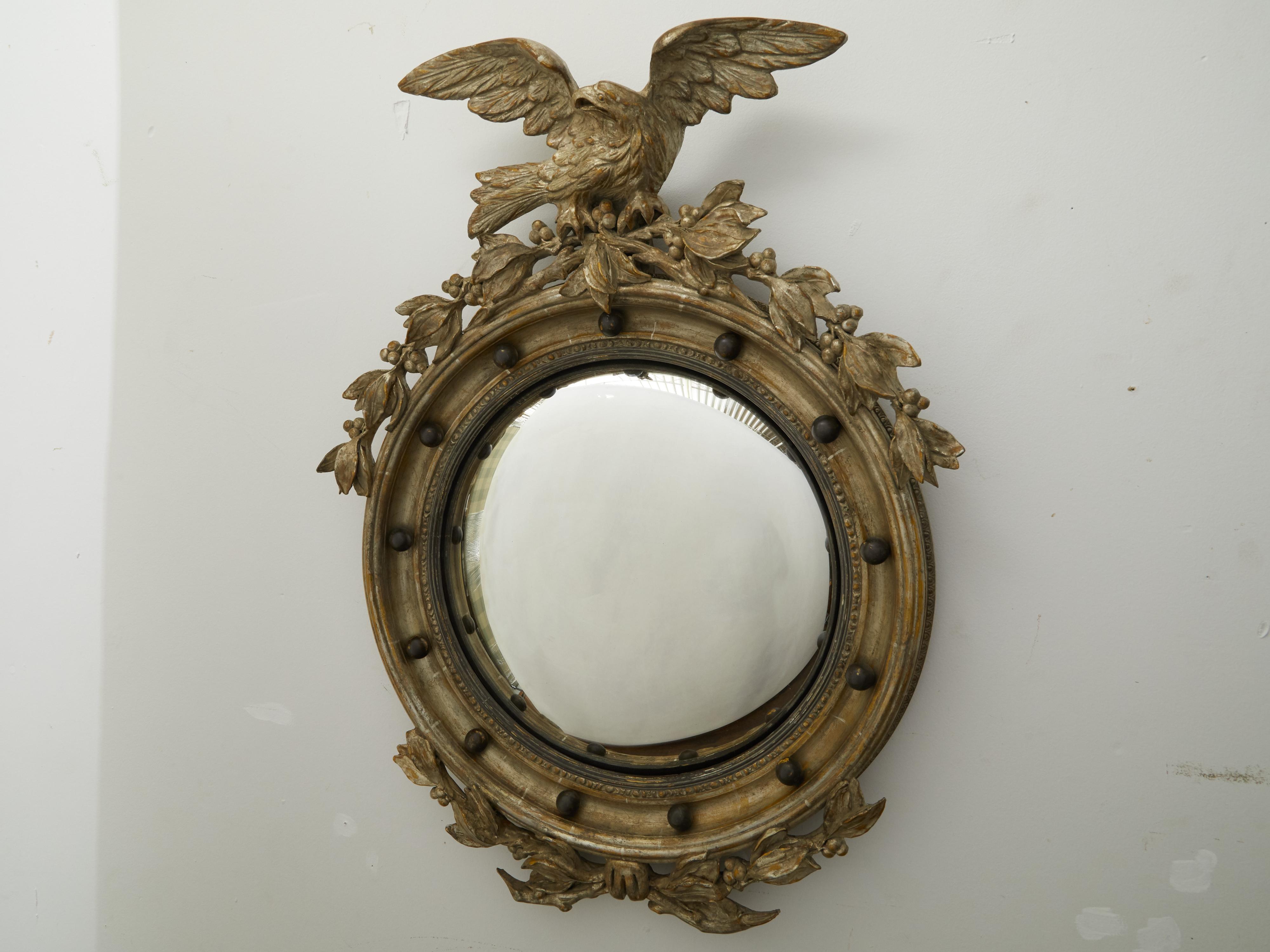 Ein englischer, vergoldeter, konvexer Girandole-Spiegel mit Adler-Motiv aus dem frühen 20. Jahrhundert. Dieser in den ersten Jahren des 20. Jahrhunderts in England hergestellte silberne Girandolenspiegel fällt durch seinen Adler auf, der den oberen