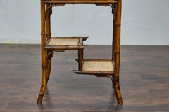 Mesa auxiliar inglesa de bambú y ratán tejido de los años 20 con estantes seccionados