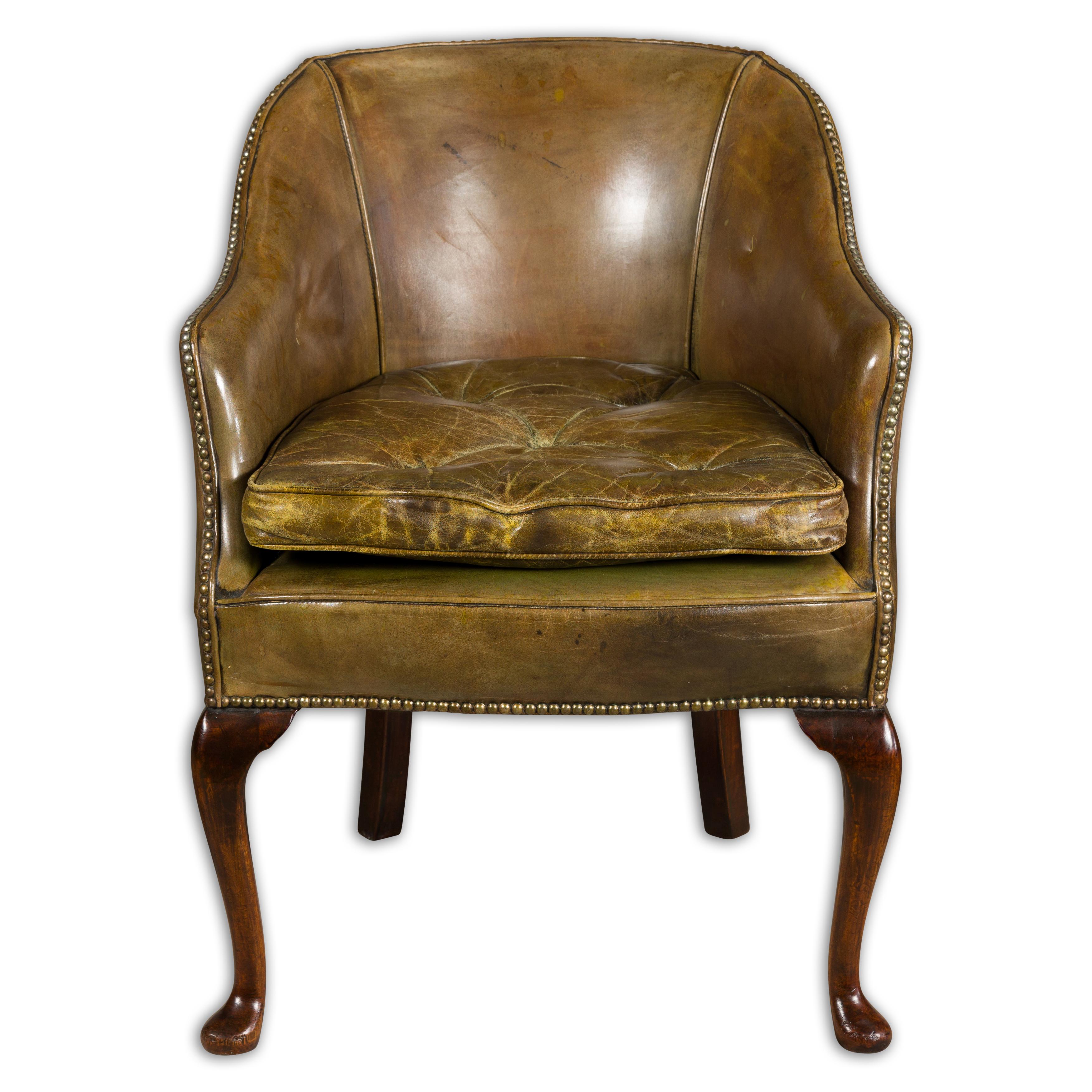 English brownish green leather chair circa 1900-1920, with carved mahogany legs. Step back in time with this English brownish green leather chair, hailing from the early 20th century (circa 1900-1920). This sophisticated piece is a wonderful