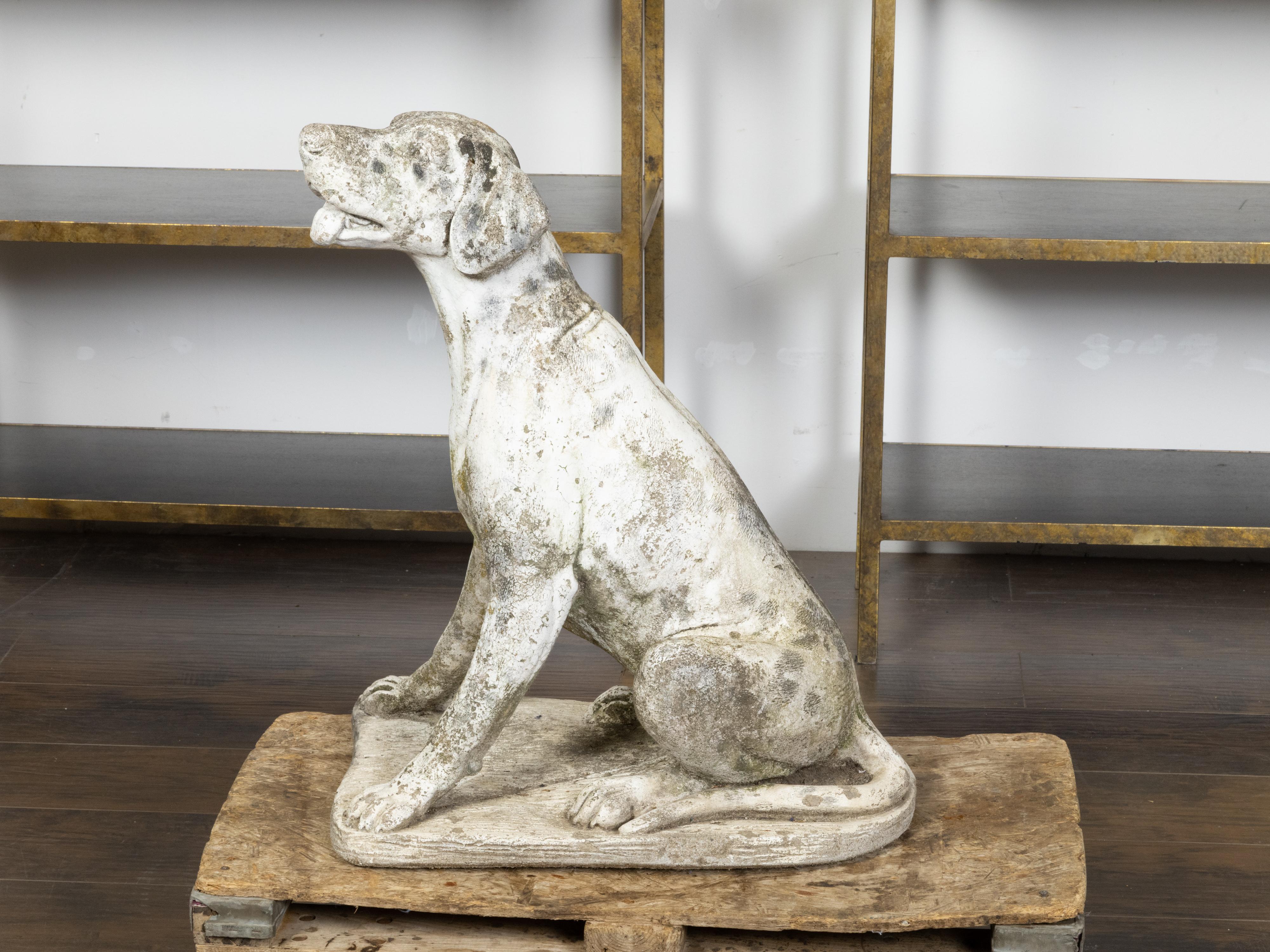 An English carved stone sculpture from the early 20th century depicting a sitting dog with nicely distressed patina. Created in England during the vibrant Roaring Twenties, this carved stone sculpture charms us with its depiction of a labrador-style