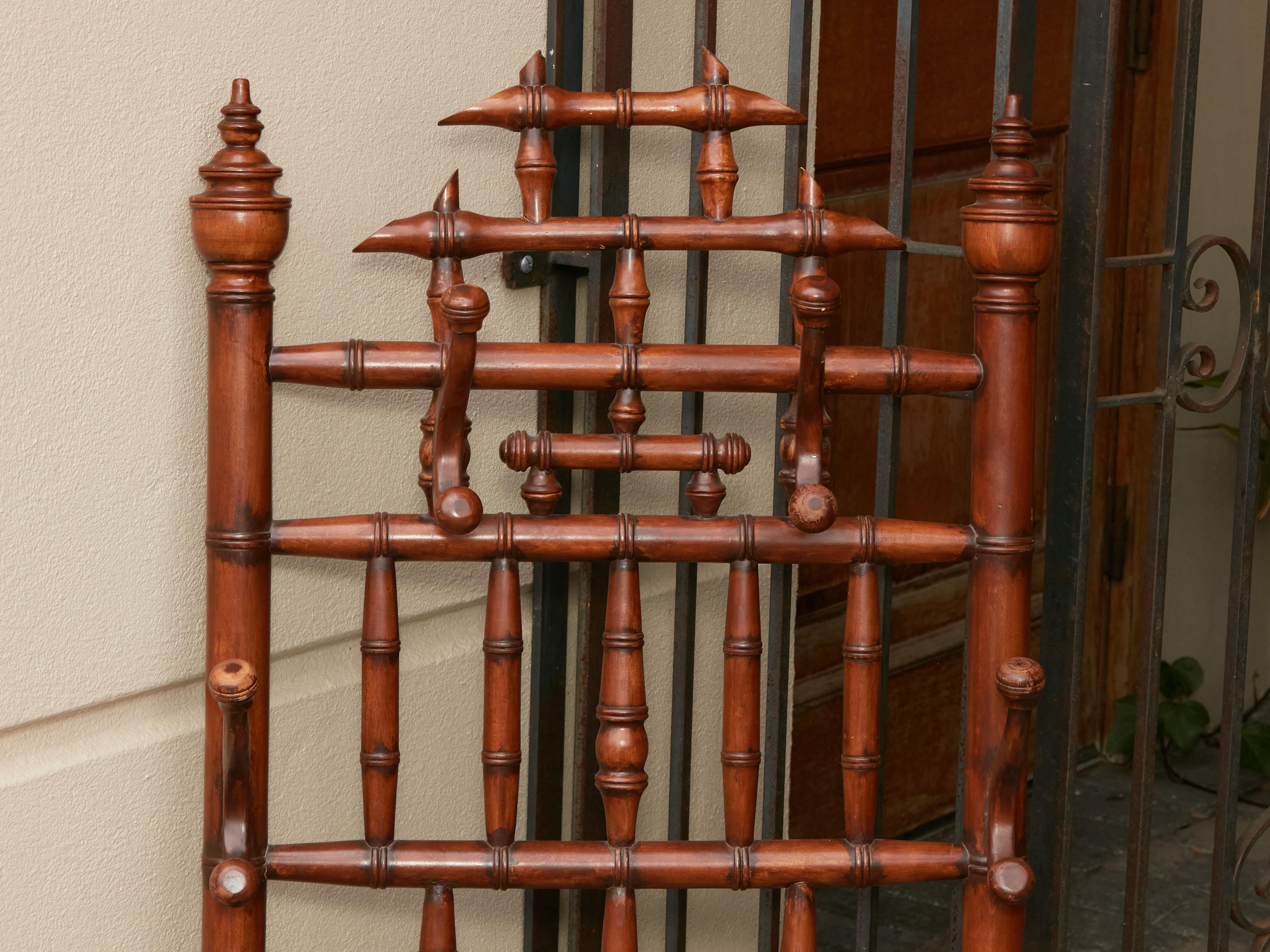 An English Chinese Chippendale style bamboo coat or hat hanger from the early 20th century, with turned accents. Created in England during the Roaring Twenties, this coat hanger attracts our attention with its Chinese Chippendale style bamboo frame