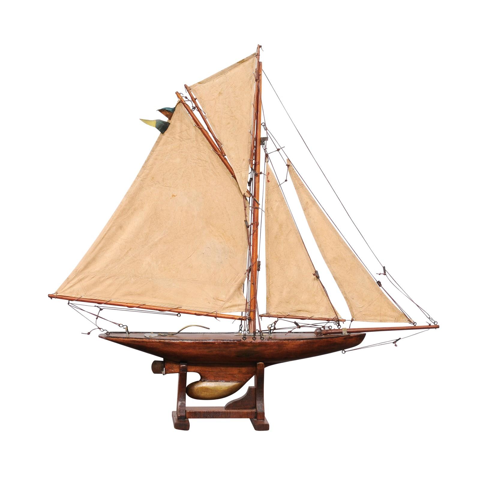 An English Gaff Cutter pond yacht from circa 1920, with solid hull and four sails. Step into the serene world of vintage nautical elegance with this English Gaff Cutter pond yacht from circa 1920, a piece that encapsulates the grace and
