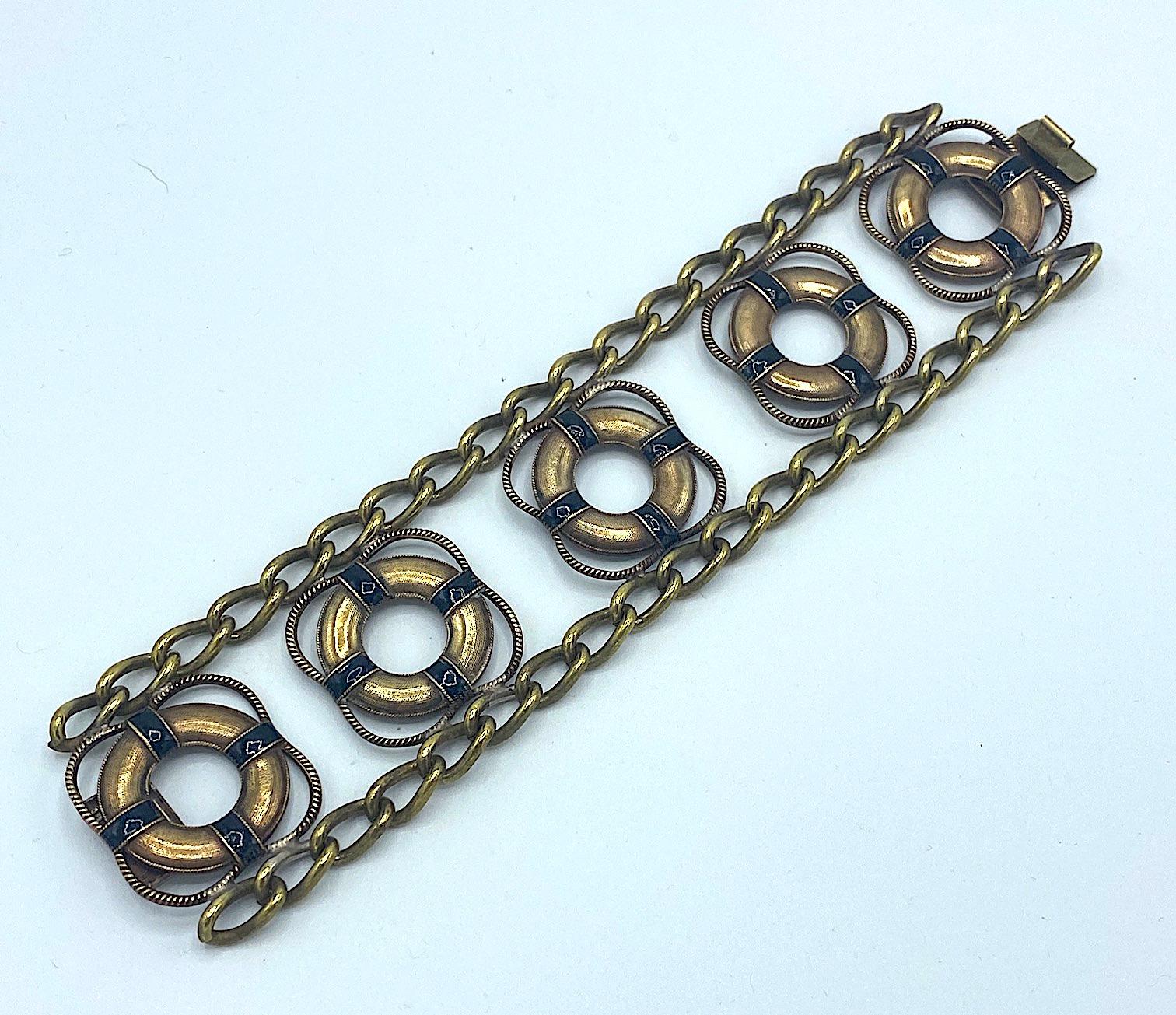 A very unusual and rare boating theme English bracelet in gold plate on brass with black enamel and dating from the late 1930s to early 1940s. The bracelet is large measuring a full 1.75 inches wide and 8 inches long including the tongue of the push