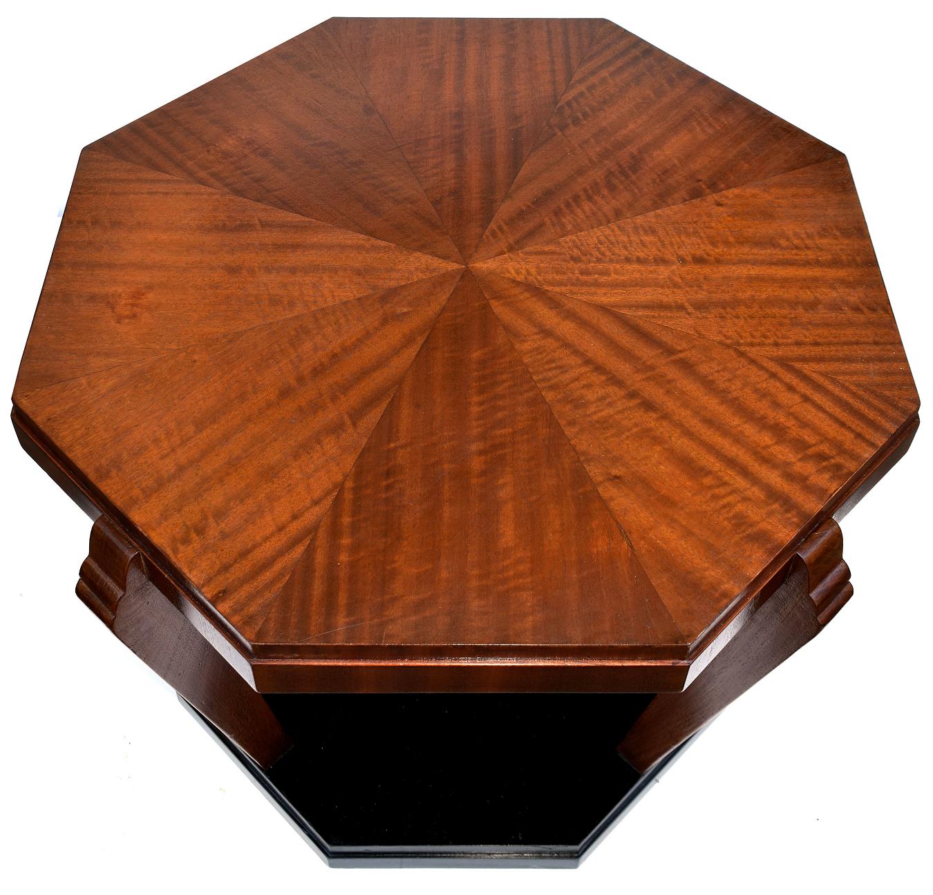 Dating to the 1930s and originating in England is this very stylish occasional table. Ideal for many settings and uses. With the combination of woods of a figured Mahogany top and legs with ebonized plinth makes for a striking look. We've had this