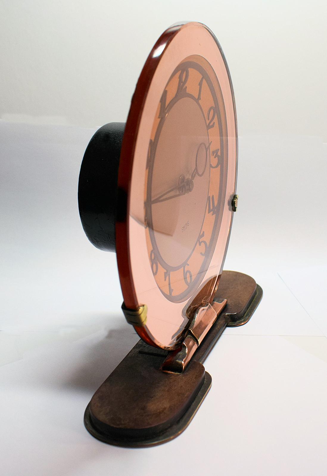 A gorgeous antique 1930s Art Deco Smiths original peach glass mirror eight day wind up mantel clock in good working condition. This clock features a peach mirrored face which is supported on a copper and black vitrolite base. We've had this clock