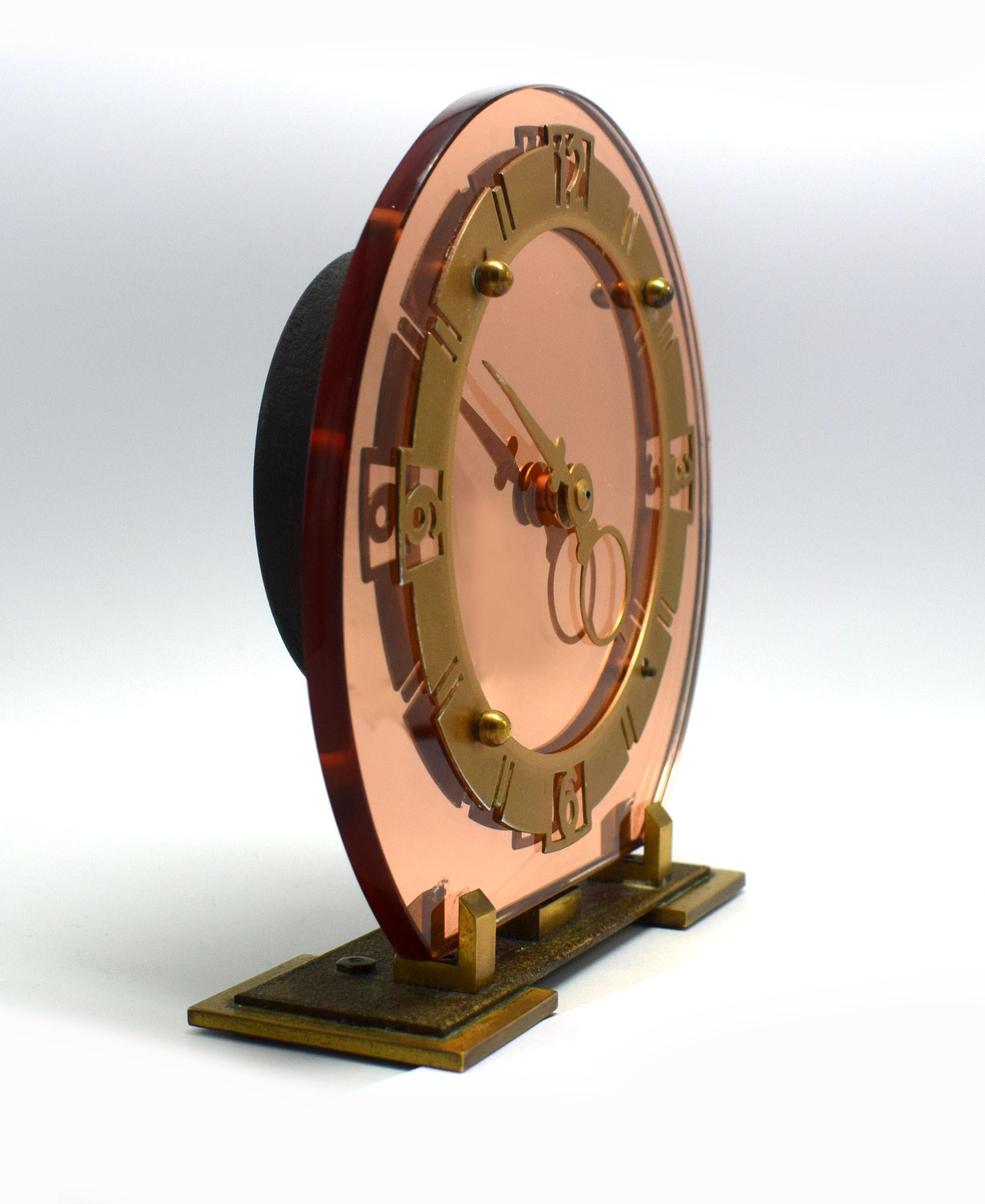 A gorgeous antique 1930s Art Deco Smiths original peach glass mirror wind up mantel clock. This clock features a peach mirrored face which is supported on a solid brass base with fretted out brass numerals and bezel. We've had this clock serviced