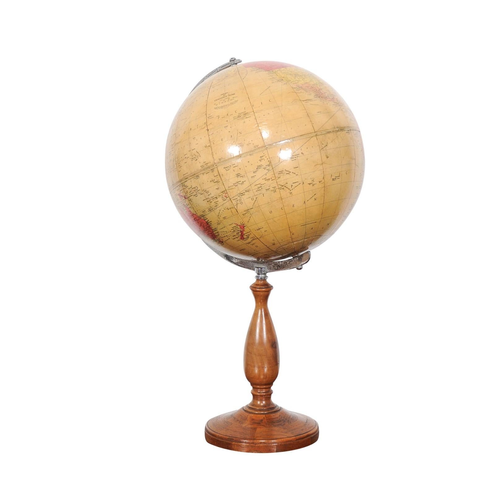 An English Philips Challenge globe from the second quarter of the 20th century mounted on a walnut base. Journey through time with this English Philips Challenge globe from the second quarter of the 20th century, a captivating piece that marries