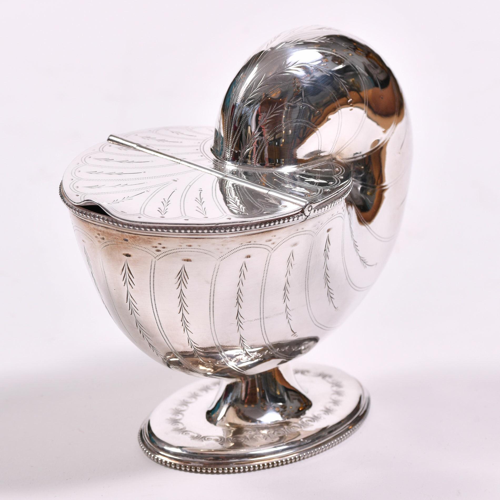 England, circa 1880s, silver plated, in the form of a large shell on a circular base, the slim lid lifting to reveal a small compartment inside. 

The Victorians used these as spoon warmers, but would make a perfect dressing table accessory.