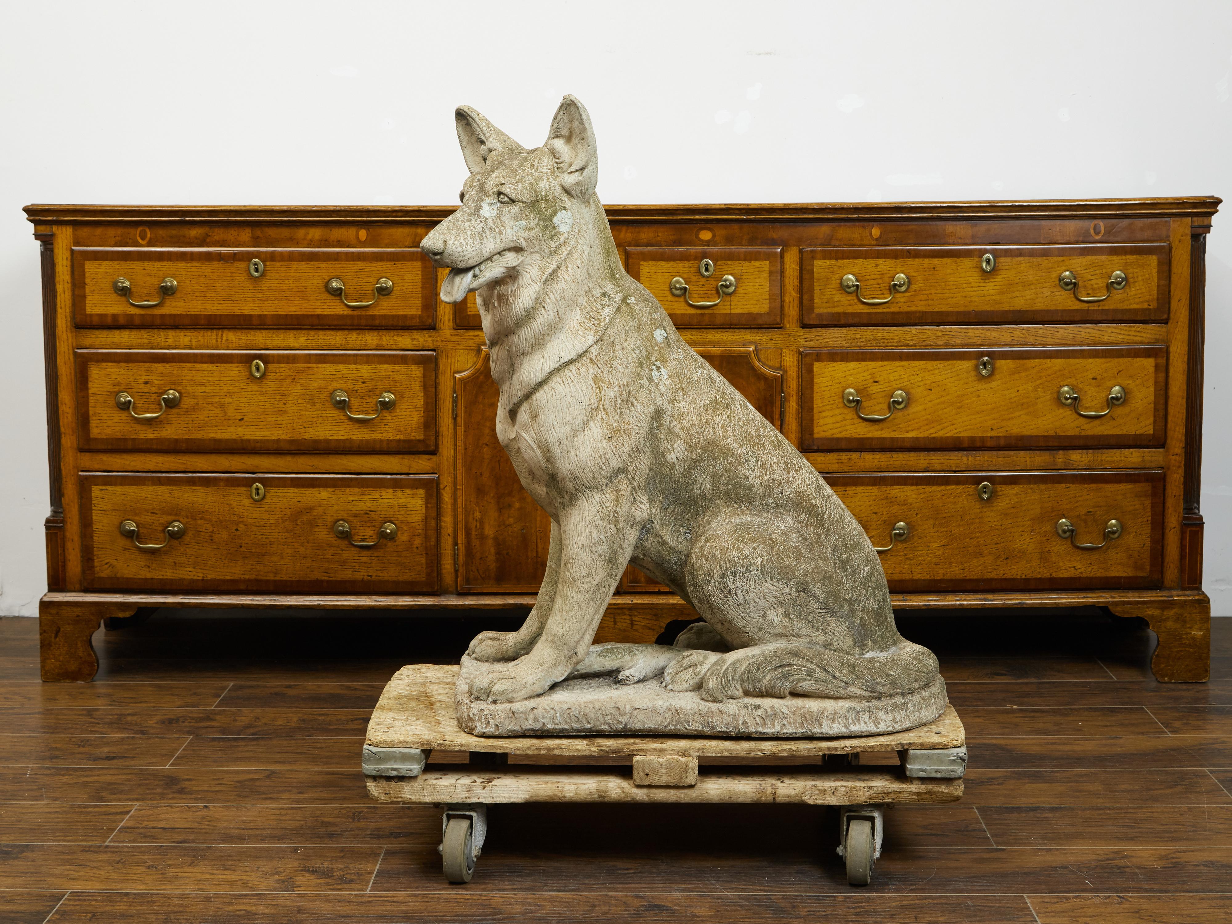 An English carved stone German Shepherd dog sculpture from the mid 20th century, on oval base. Created in England during the second quarter of the 20th century, this stone German Shepherd sculpture charms us with its skillful depiction and nicely