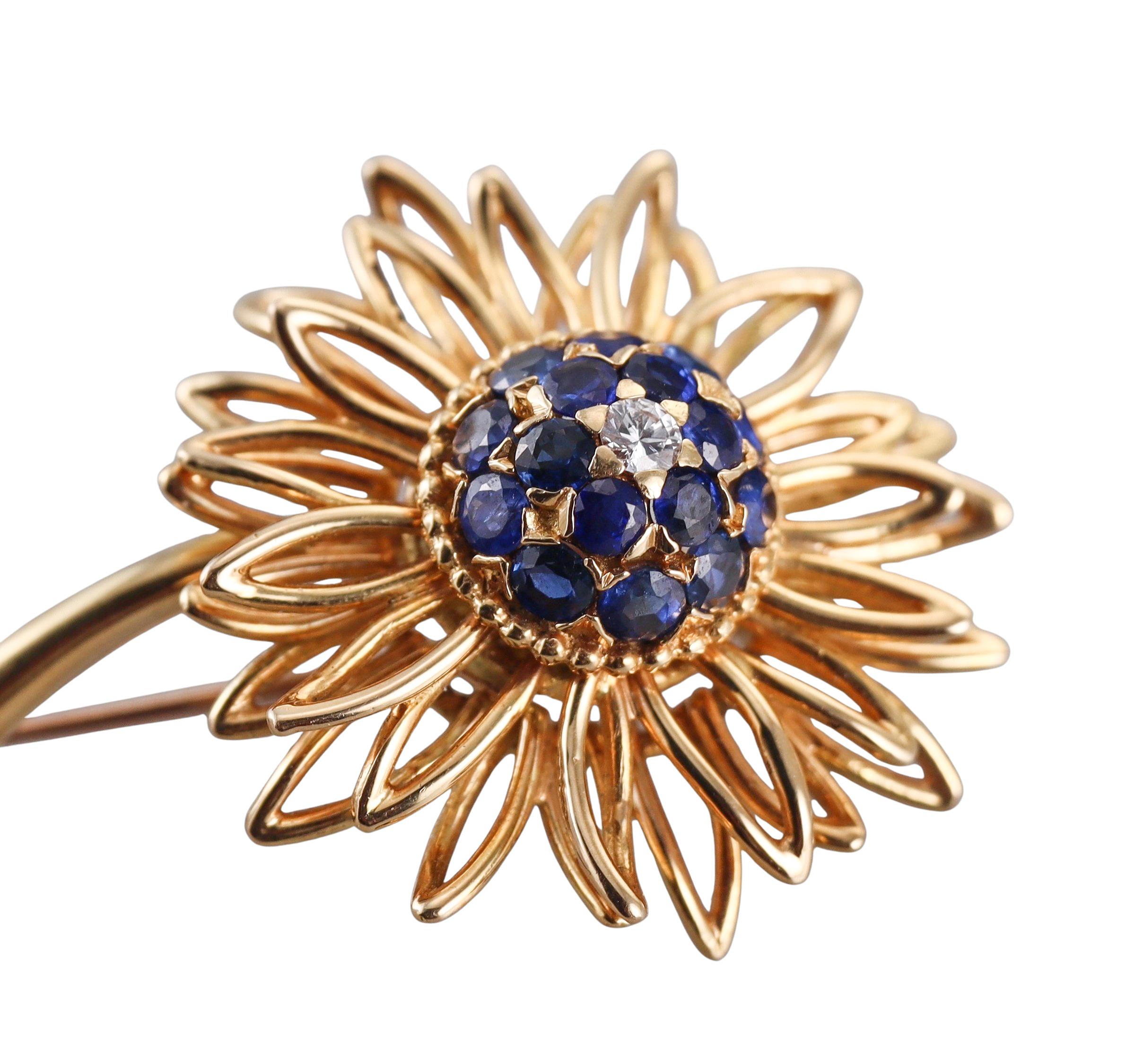 An 18k yellow gold flower brooch, English made. Set with sapphires and approx. 0.06ct diamond. 
Brooch measures 1.5