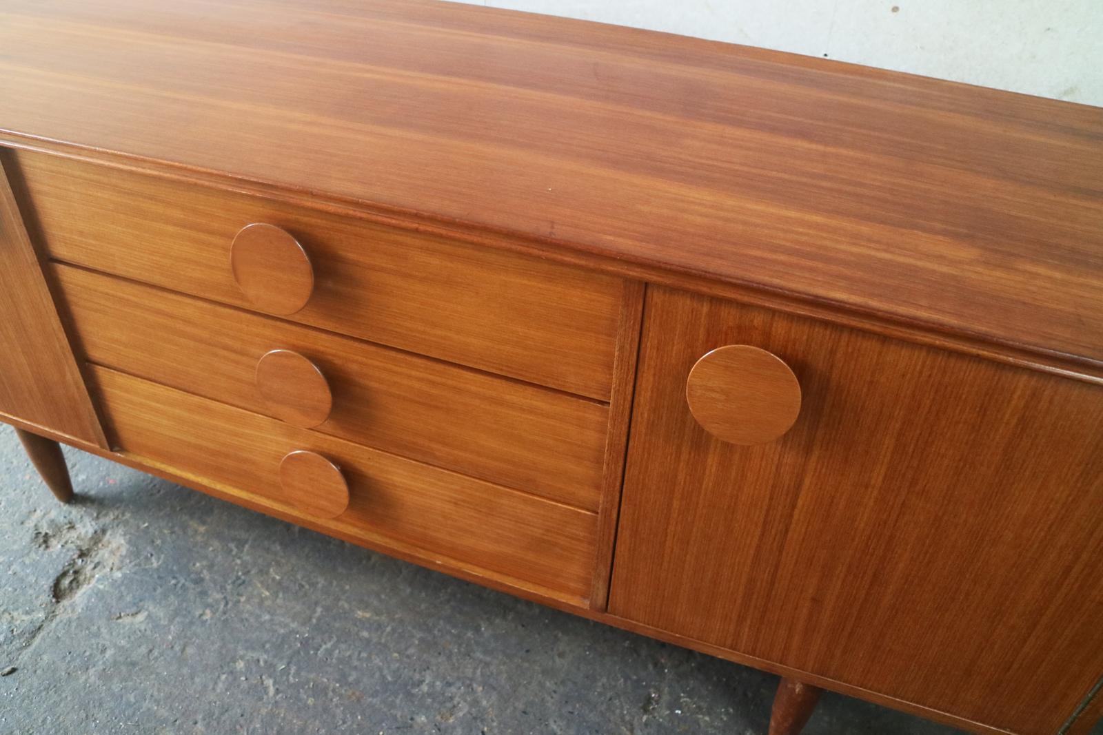 The large round slightly bevelled handles are the outstanding feature of this small but beautifully formed sideboard. 

