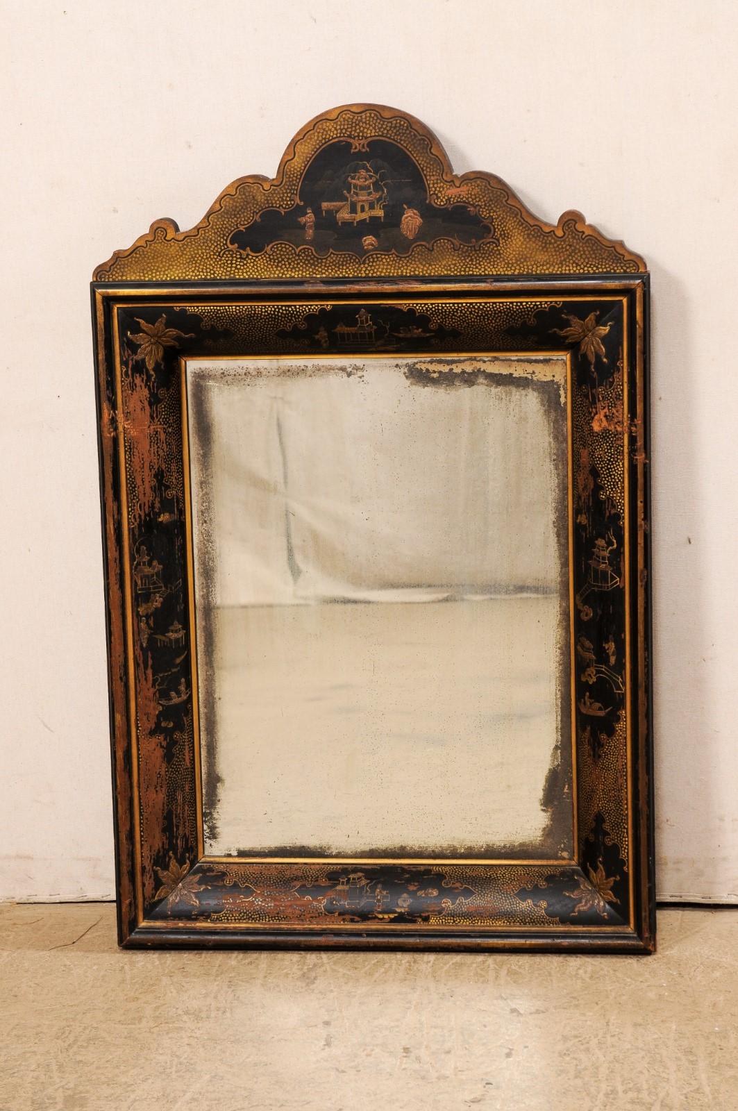 An English chinoiserie decorated wall mirror from the 19th century. This antique wall mirror from England has a nicely carved crest at top adorn in chinoiserie featuring an Asian landscape within its center. The rectangular frame which surrounds the