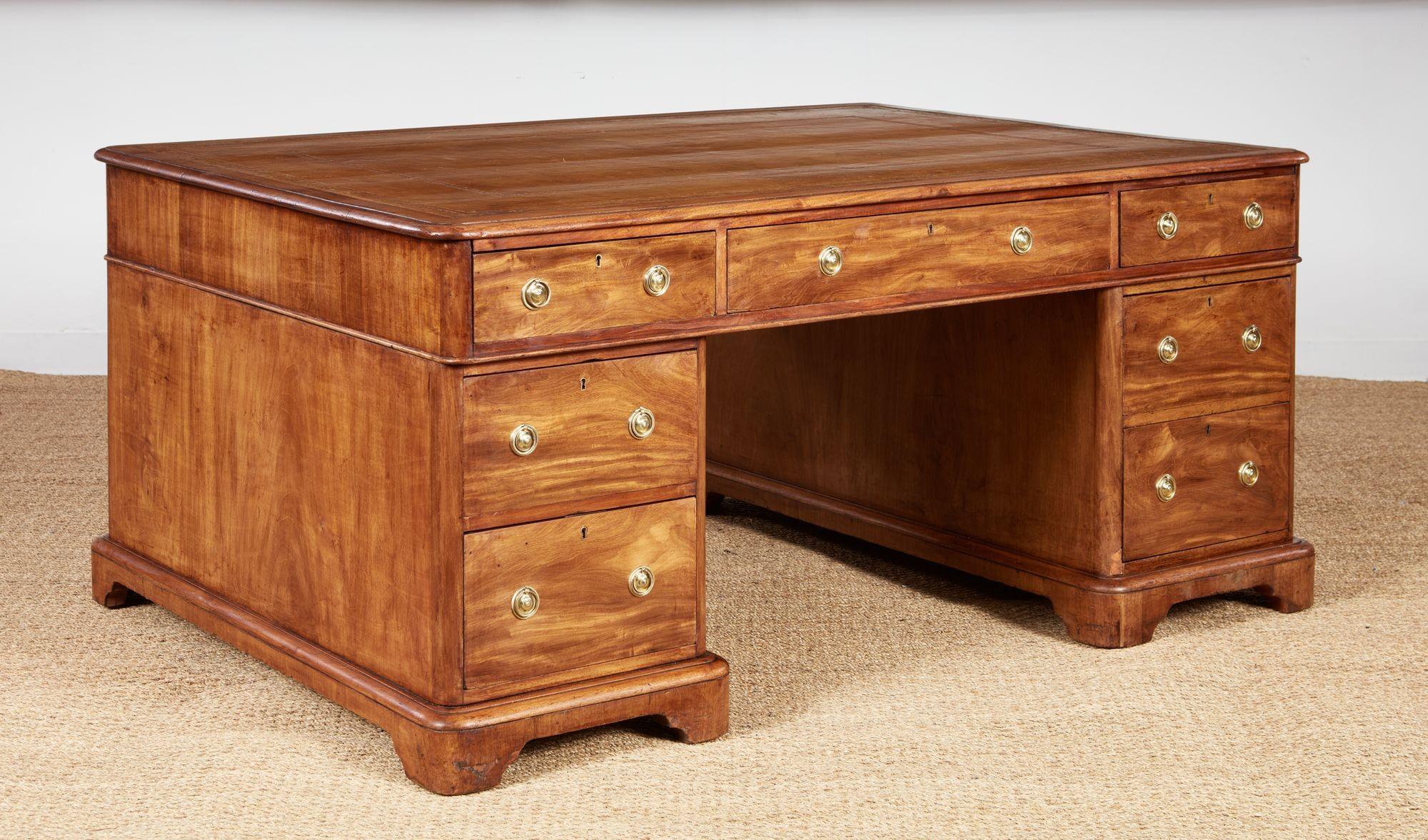 A handsome and generously sized partners' desk with glowing color, the two sides made so that business partners could collaborate over the same writing surface, now suitable for central placement in a room as it can be viewed from any angle, having