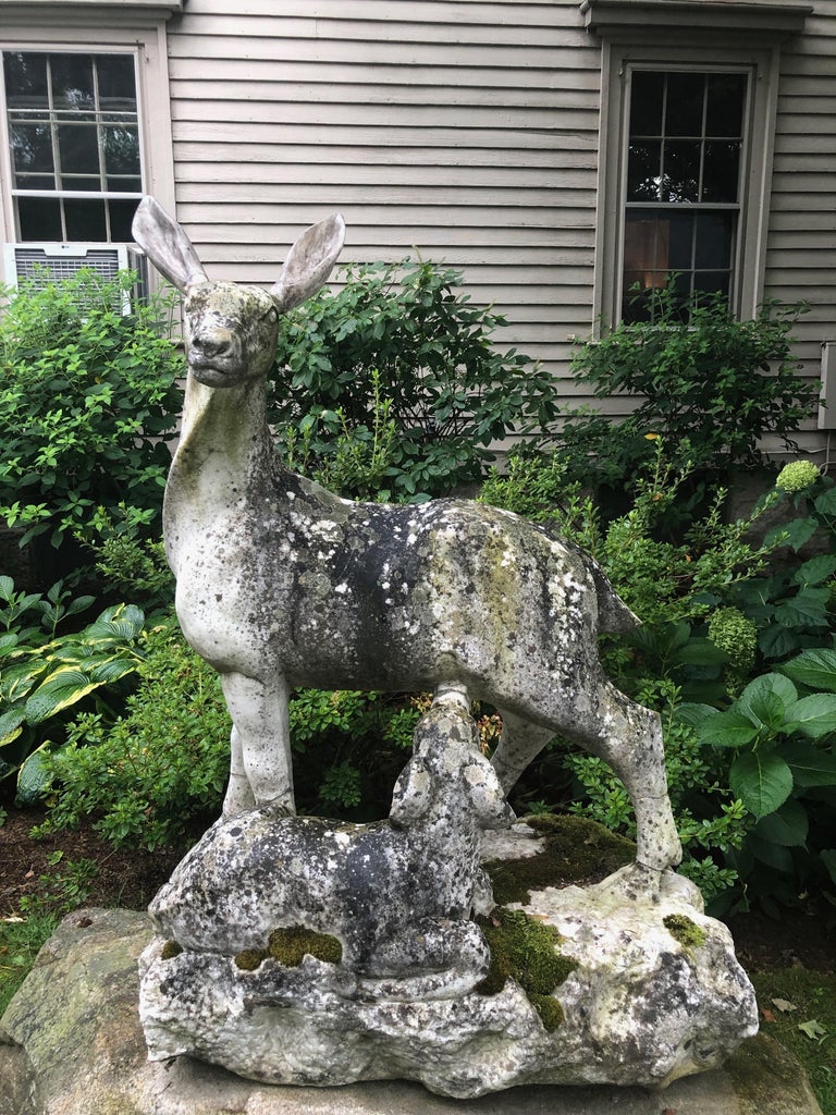 We were thrilled to have found this amazing marble statue in England, even though the ears on the doe have been replaced and recently colored. With an incredible lichened and mossy surface, the piece depicts a nursing fawn and sits atop a boulder we