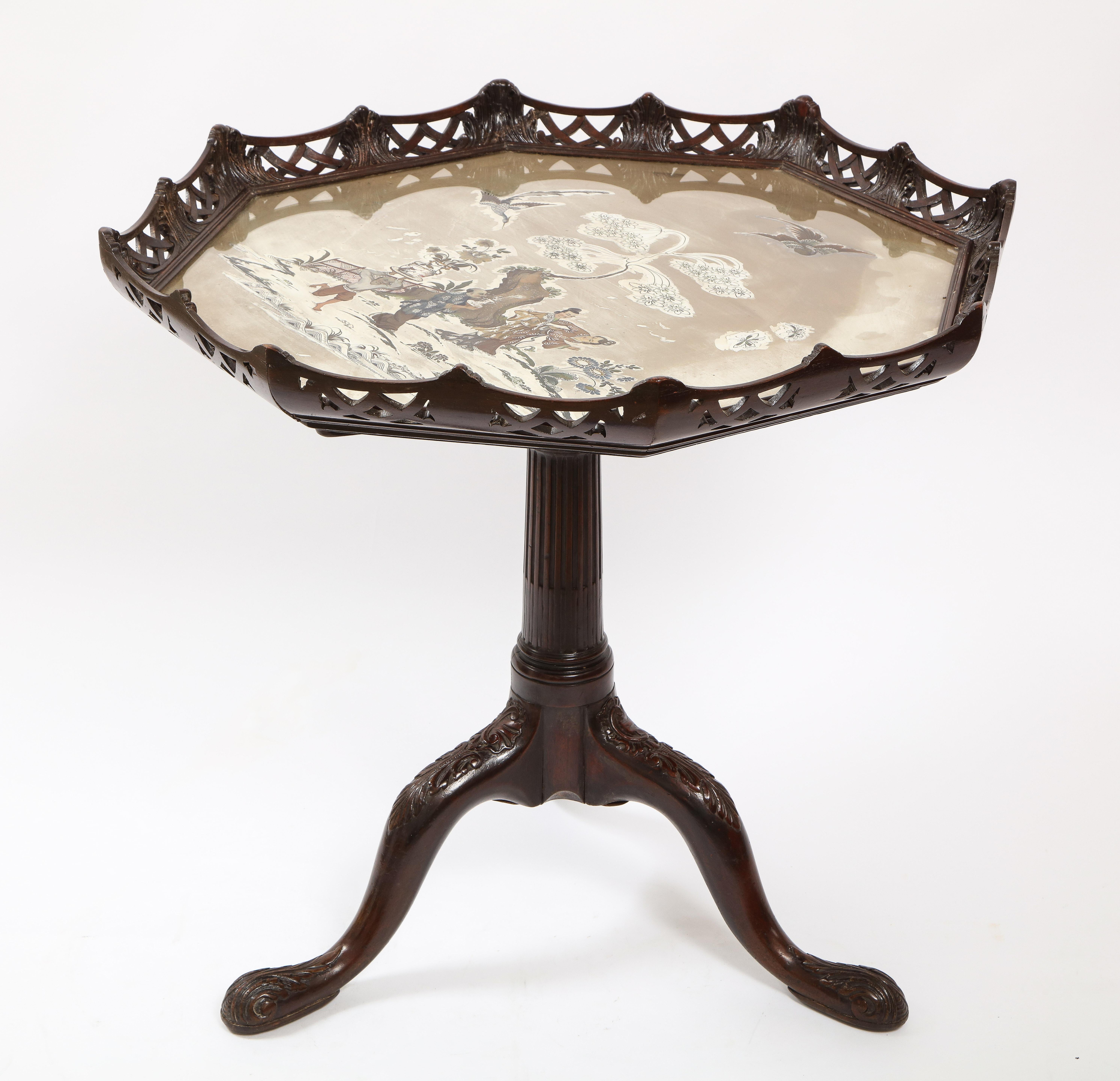 An unusual and fabulous 19th century English George the II/III style Octagonal hand-carved Mahogany tilt-top table with a silvered Chinoiseries Reverse on glass mirrored top. This table truly beautiful with an open-work wood top border in a lattice